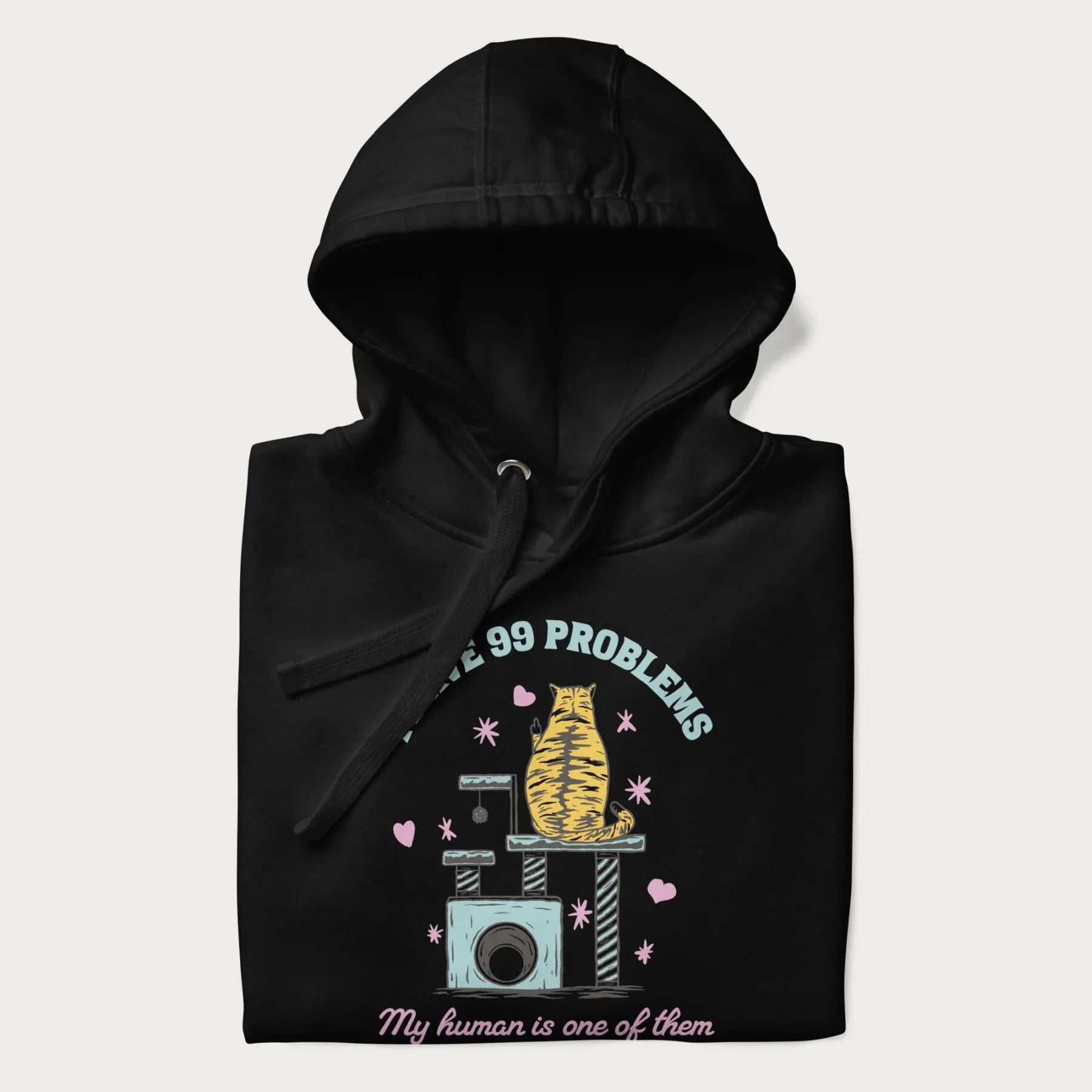 Folded black hoodie with graphic of a cat on a scratching post and text 'i have 99 problems, my human is one of them'.