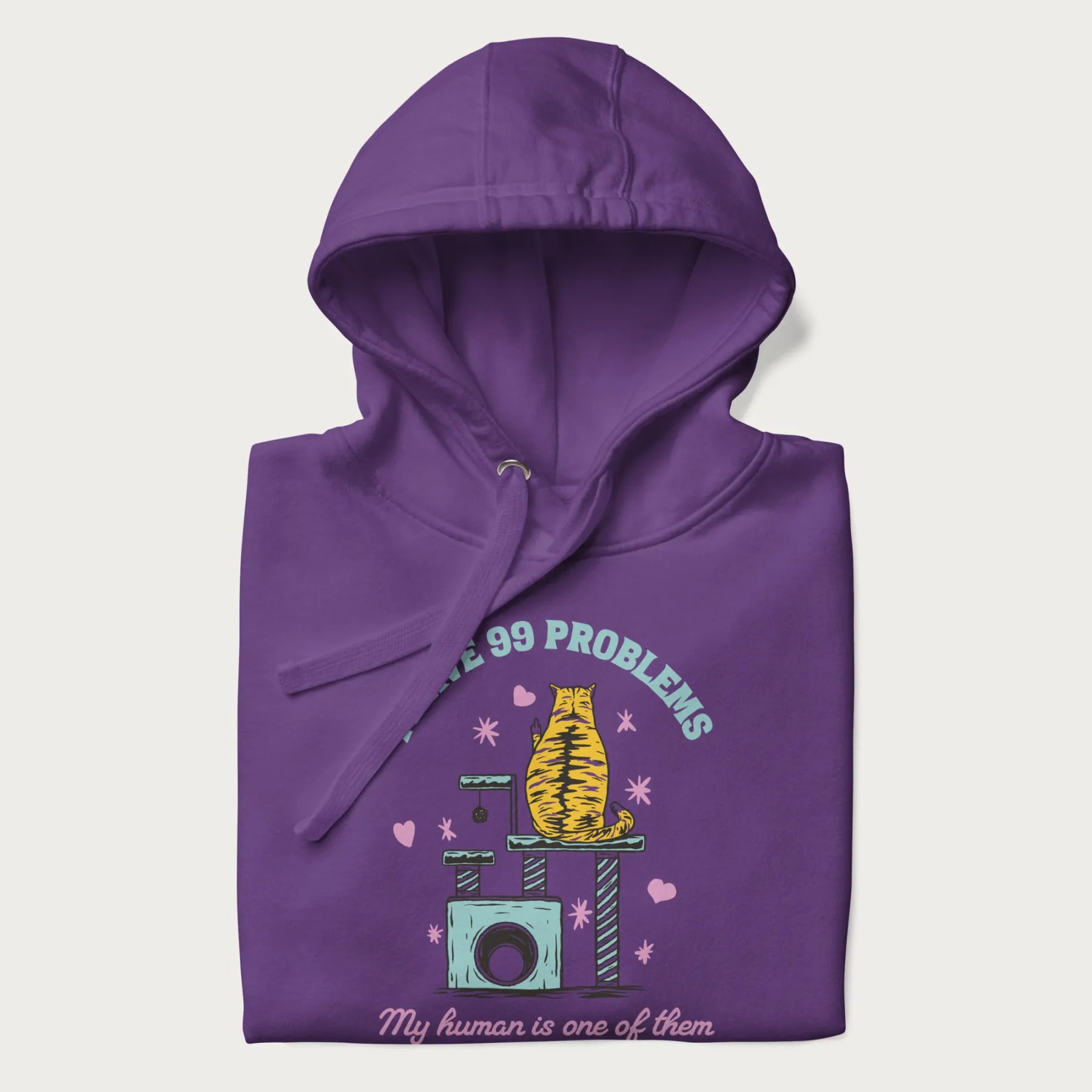 Folded purple hoodie with graphic of a cat on a scratching post and text 'i have 99 problems, my human is one of them'.