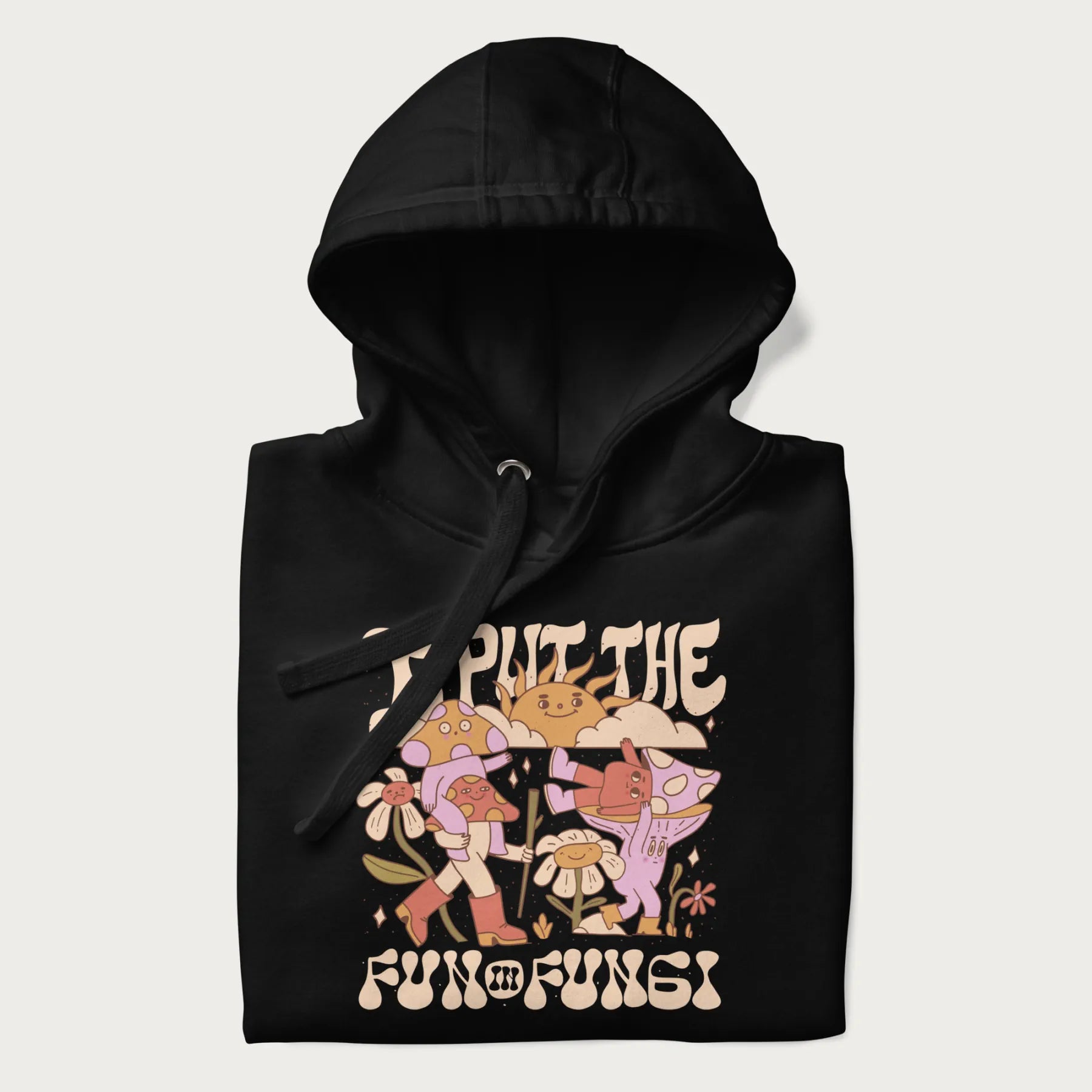 Folded black hoodie with a graphic of cheerful mushroom characters and the text 'I Put the Fun in Fungi'.