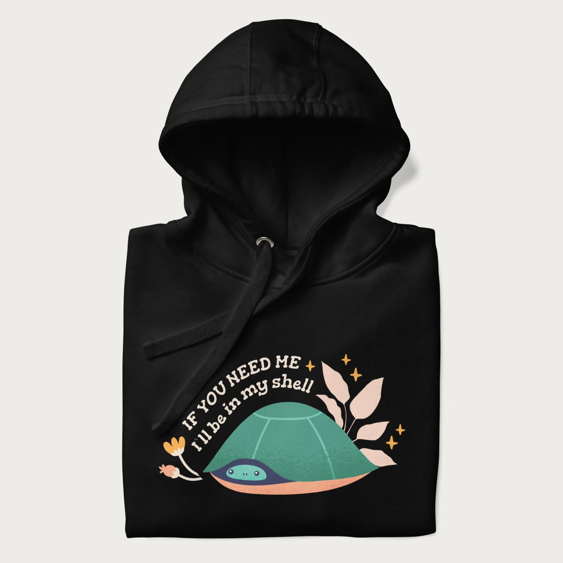 Folded black hoodie with a graphic of a turtle peeking out from its shell and the text 'If You Need Me I'll be in my shell'.