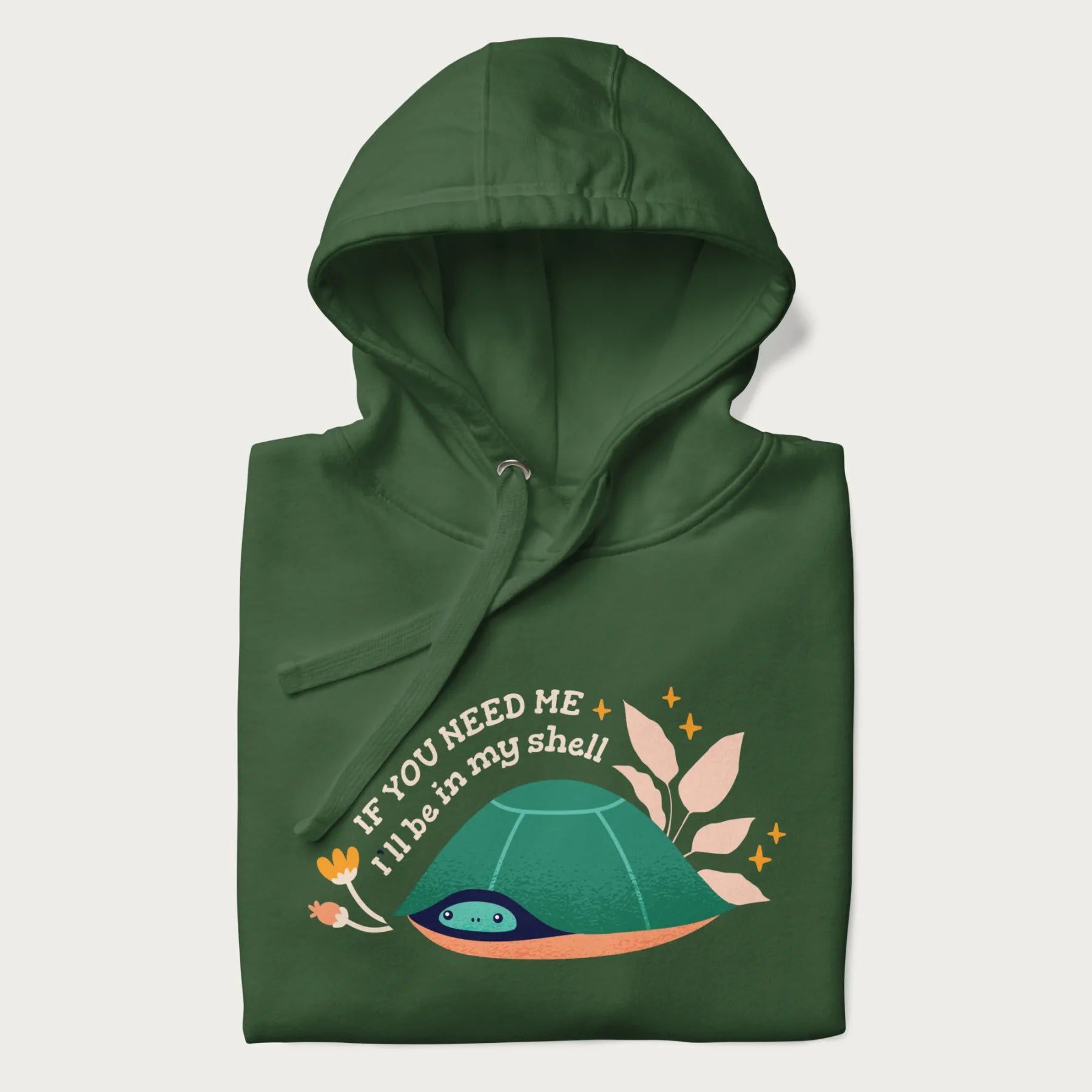 Folded forest green hoodie with a graphic of a turtle peeking out from its shell and the text 'If You Need Me I'll be in my shell'.