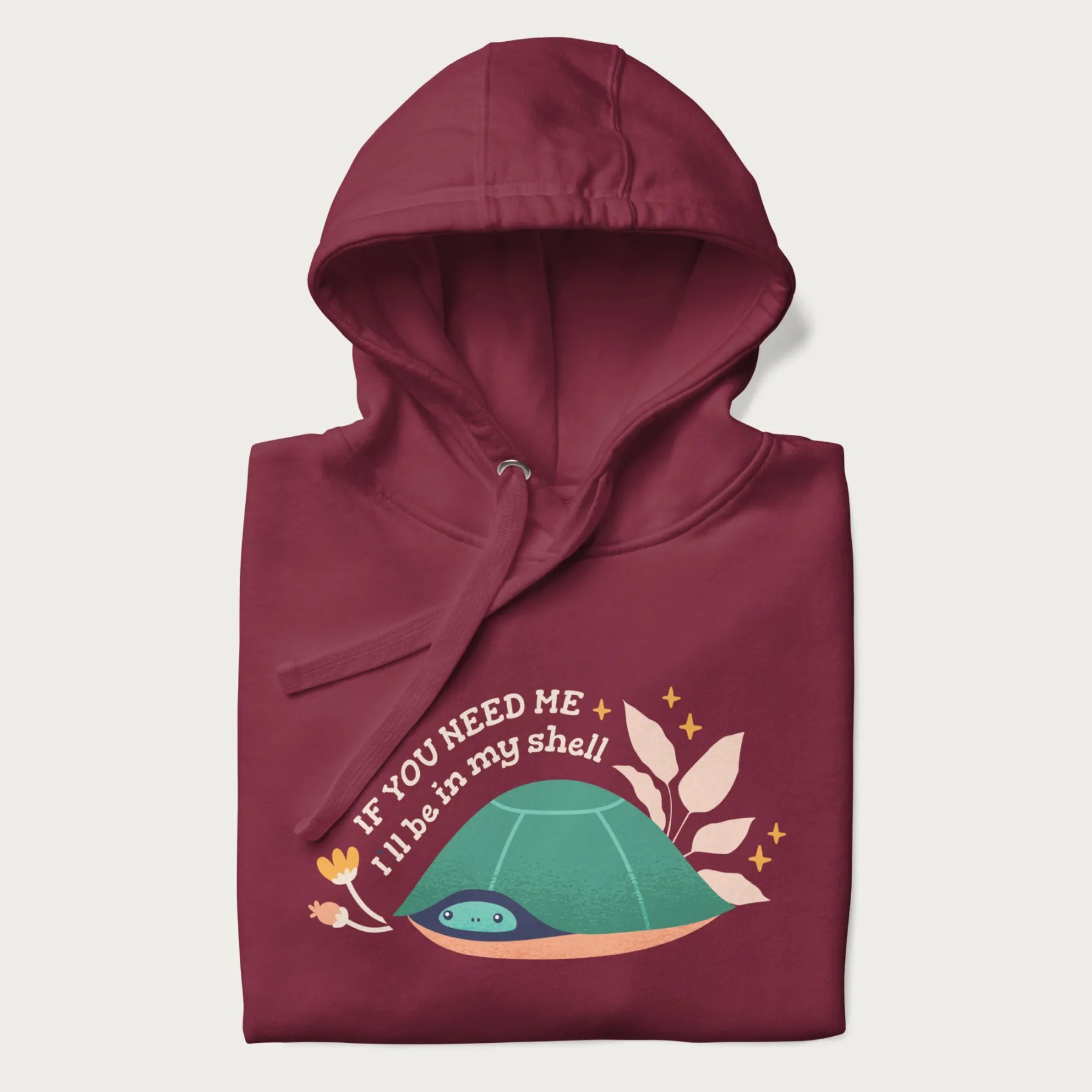 Folded maroon hoodie with a graphic of a turtle peeking out from its shell and the text 'If You Need Me I'll be in my shell'.