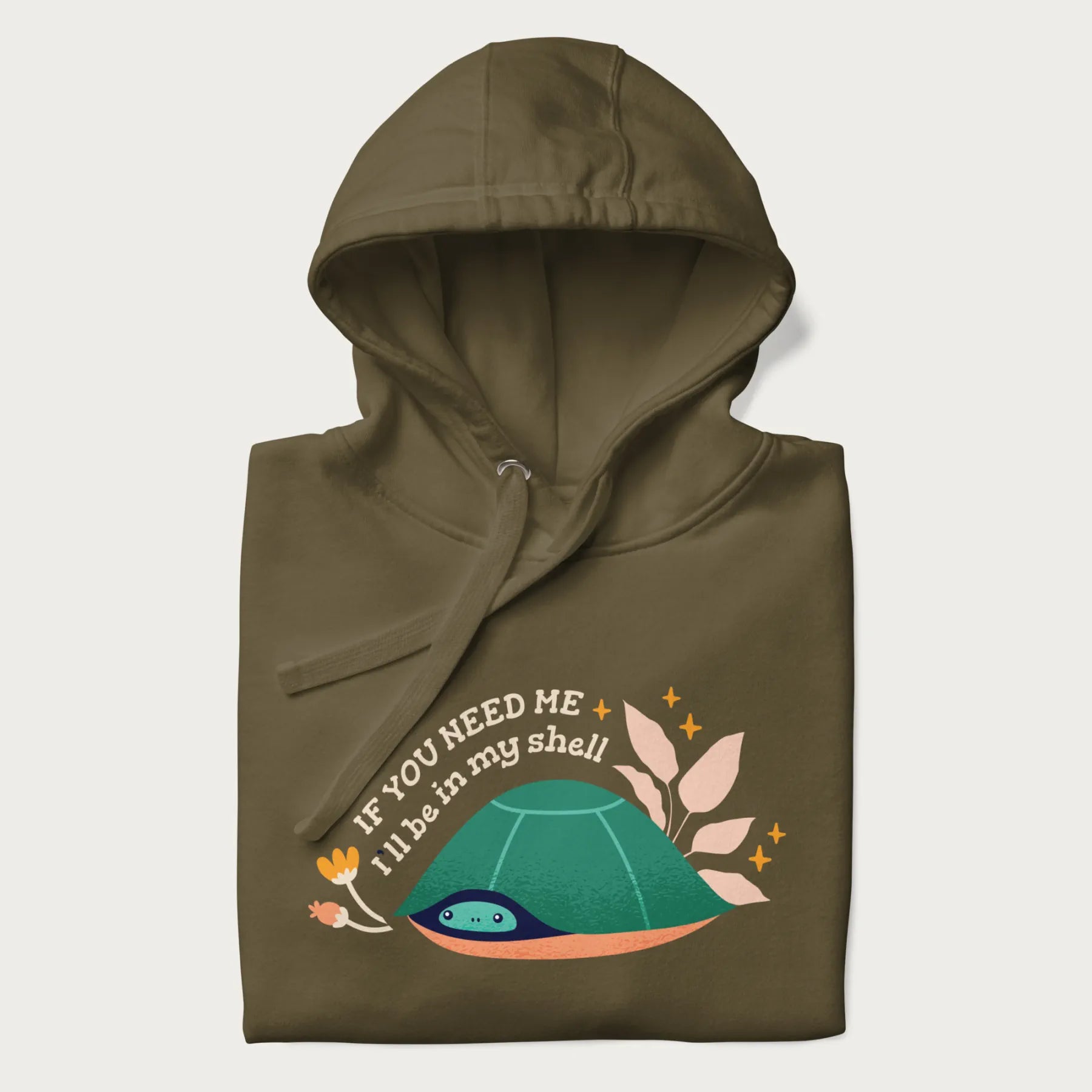Folded military green hoodie with a graphic of a turtle peeking out from its shell and the text 'If You Need Me I'll be in my shell'.