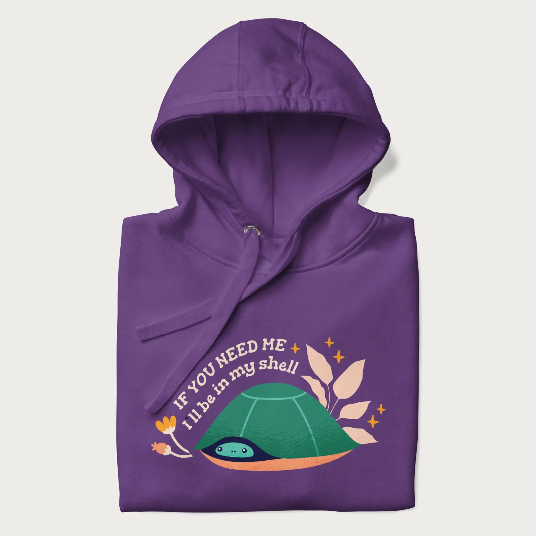 Folded purple hoodie with a graphic of a turtle peeking out from its shell and the text 'If You Need Me I'll be in my shell'.