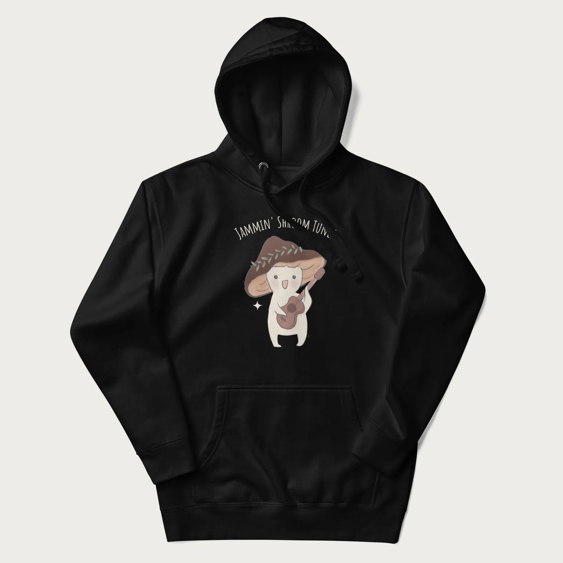 Black hoodie with a cute cottagecore mushroom character playing a guitar and the pun 'Jammin' Shroom Tunes' above.