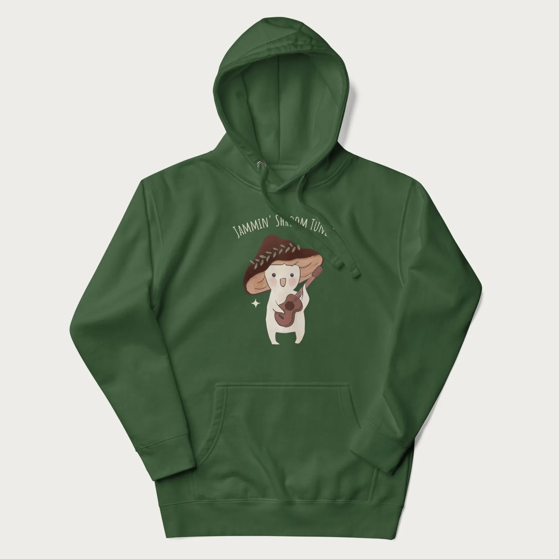 Forest green hoodie with a cute cottagecore mushroom character playing a guitar and the pun 'Jammin' Shroom Tunes' above.