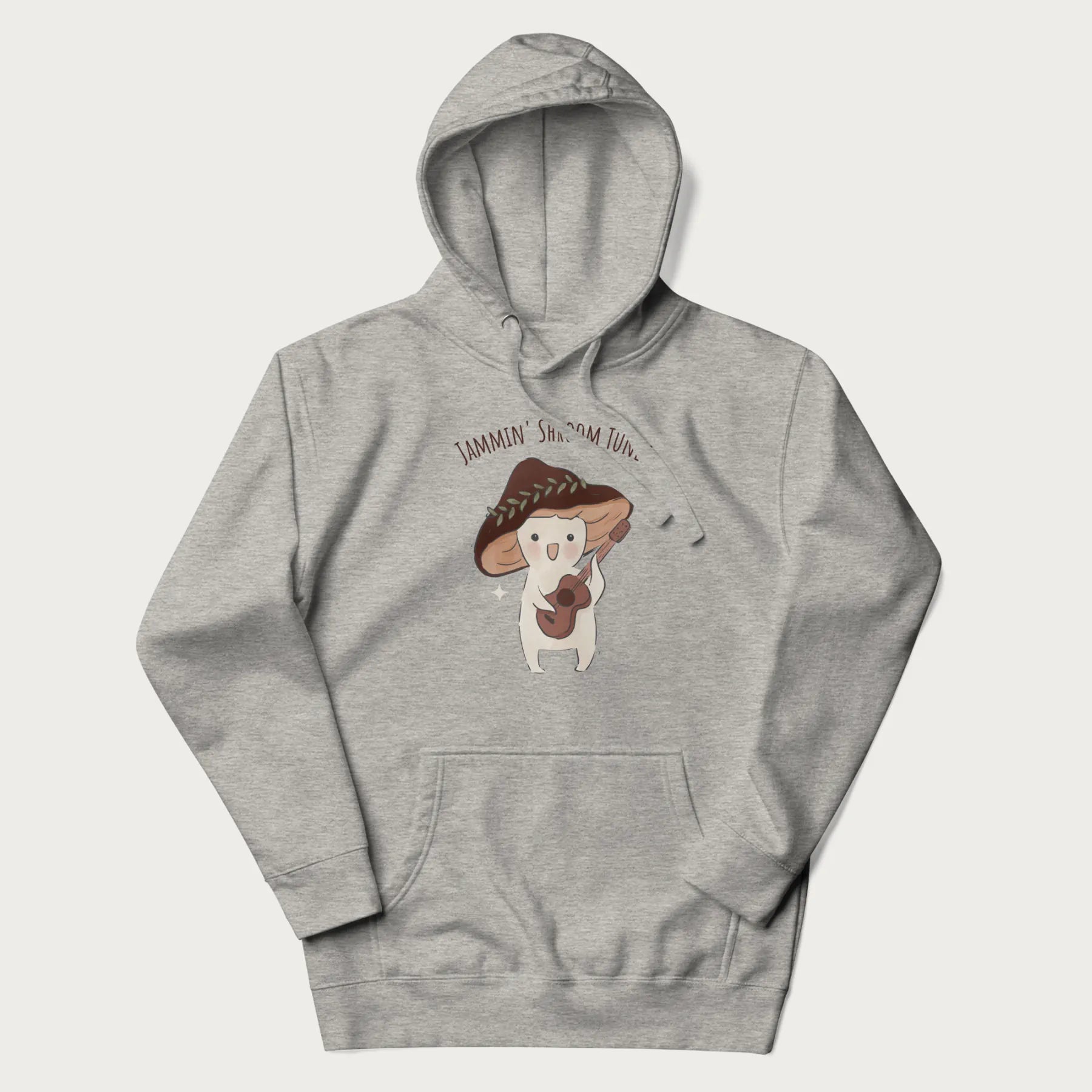 Light grey hoodie with a cute cottagecore mushroom character playing a guitar and the pun 'Jammin' Shroom Tunes' above.