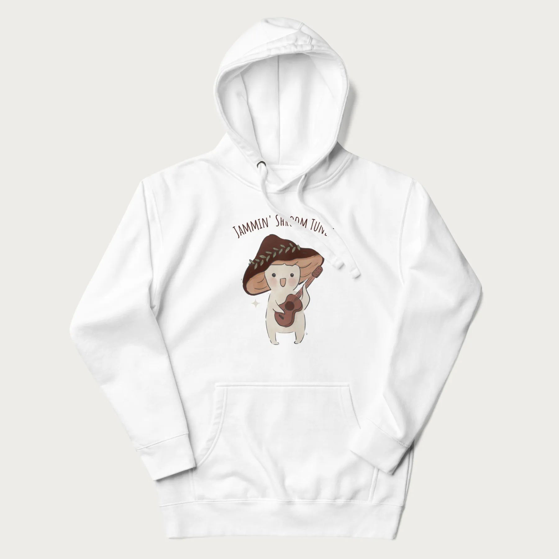 White hoodie with a cute cottagecore mushroom character playing a guitar and the pun 'Jammin' Shroom Tunes' above.