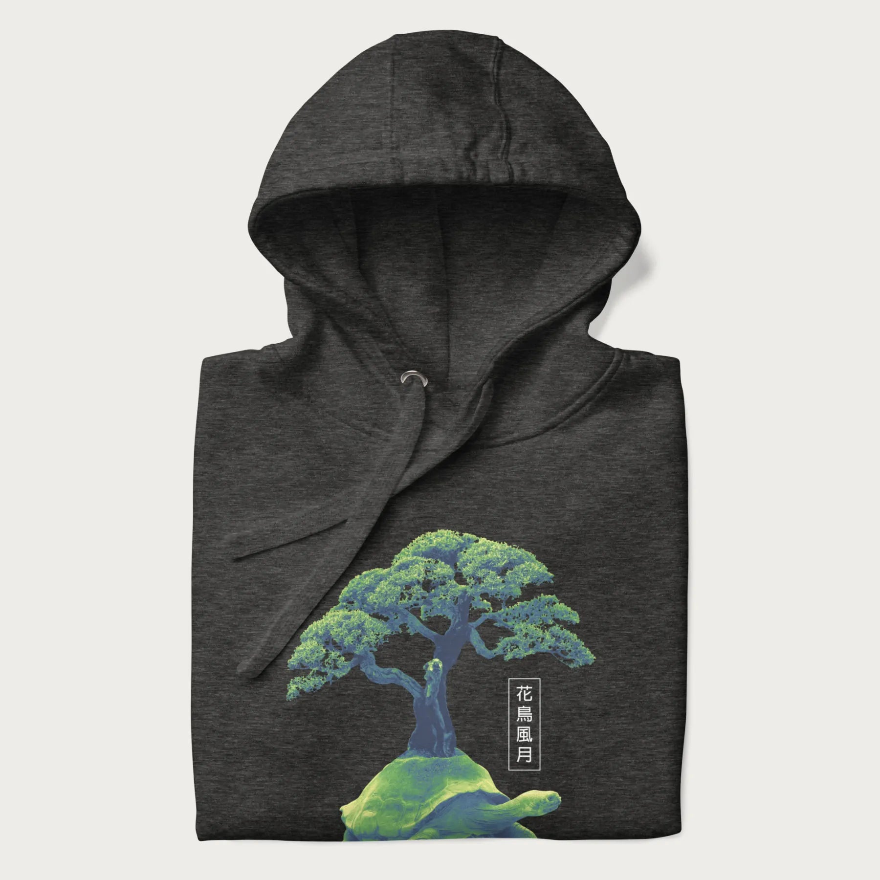 Folded dark grey hoodie with a vibrant graphic of a turtle carrying a bonsai tree and Japanese text '花鳥風月.'