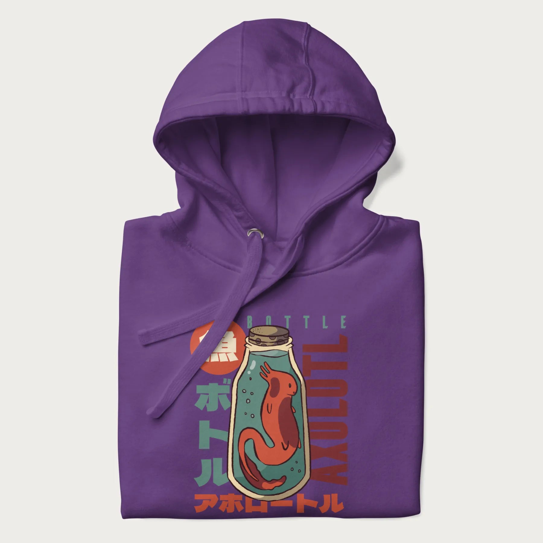 Folded purple hoodie with Japanese graphic of a red axolotl in a bottle with Japanese text 'ボトル' (Bottle) and 'アホロートル' (Axolotl).