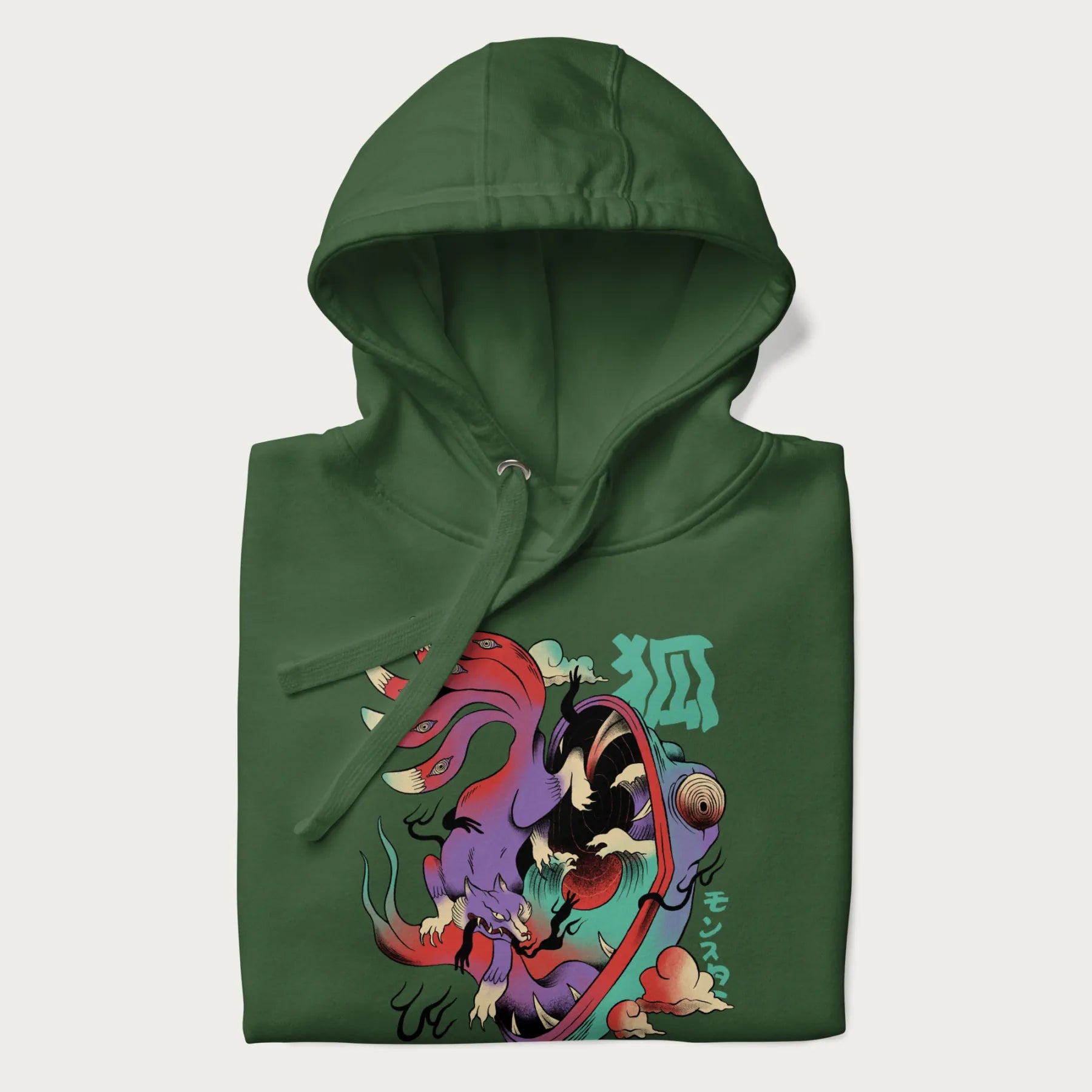 Folded forest green hoodie with Japanese 9 tailed fox graphic and Japanese text '狐' (Fox) and 'モンスター' (Monster), in vivid psychedelic colors.
