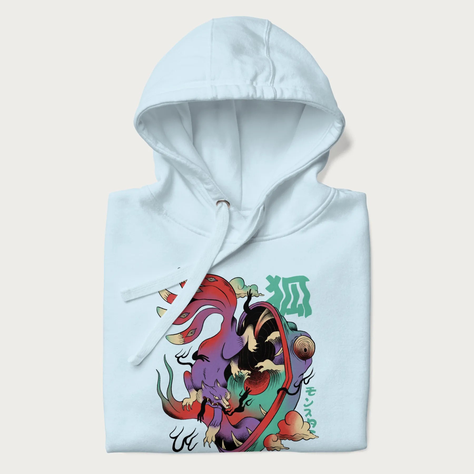 Folded light blue hoodie with Japanese 9 tailed fox graphic and Japanese text '狐' (Fox) and 'モンスター' (Monster), in vivid psychedelic colors.