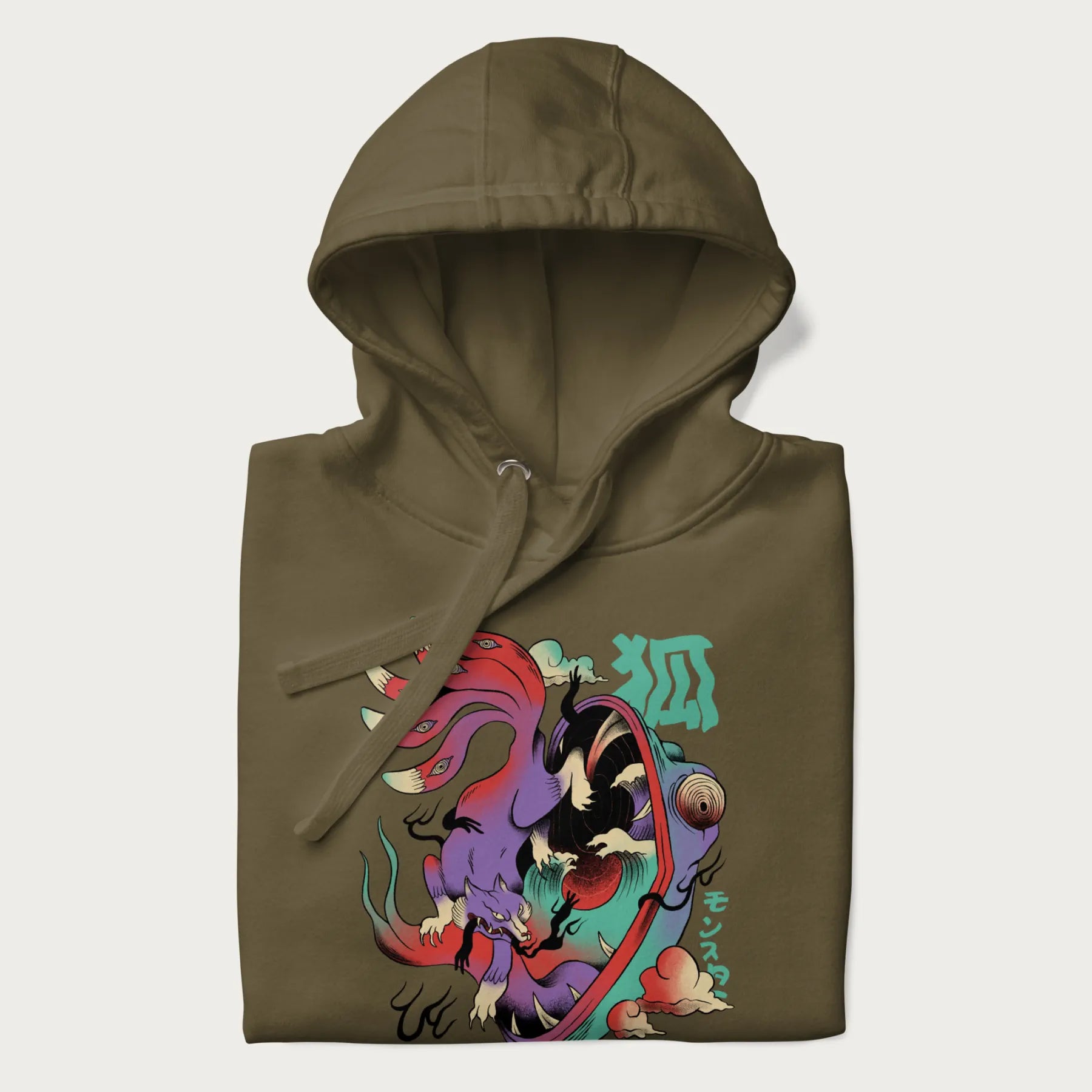 Folded military green hoodie with Japanese 9 tailed fox graphic and Japanese text '狐' (Fox) and 'モンスター' (Monster), in vivid psychedelic colors.
