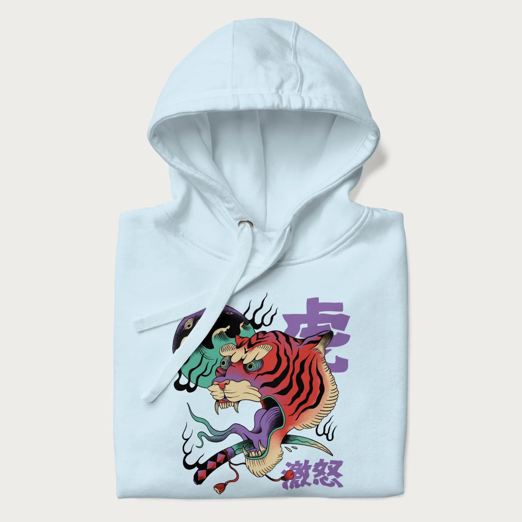 Folded light blue hoodie with Japanese tiger graphic, rendered in vivid orange and purple, with Japanese text '虎' (Tiger) and '激怒' (Rage).