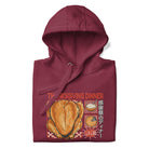 Folded Japanese Thanksgiving Hoodie in Maroon color: A warm maroon-colored hoodie featuring a graphic print showcasing a Japanese Thanksgiving feast, including a roast chicken, Japanese potato salad, and an apple pie. The hoodie is neatly folded.