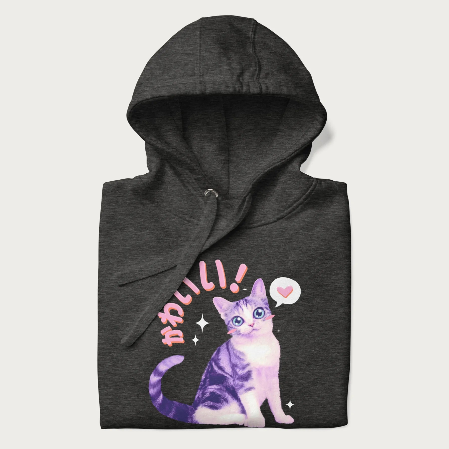 Folded dark grey hoodie with a graphic of a blue-eyed kitten and Japanese kawaii-style lettering, stars, and a heart.