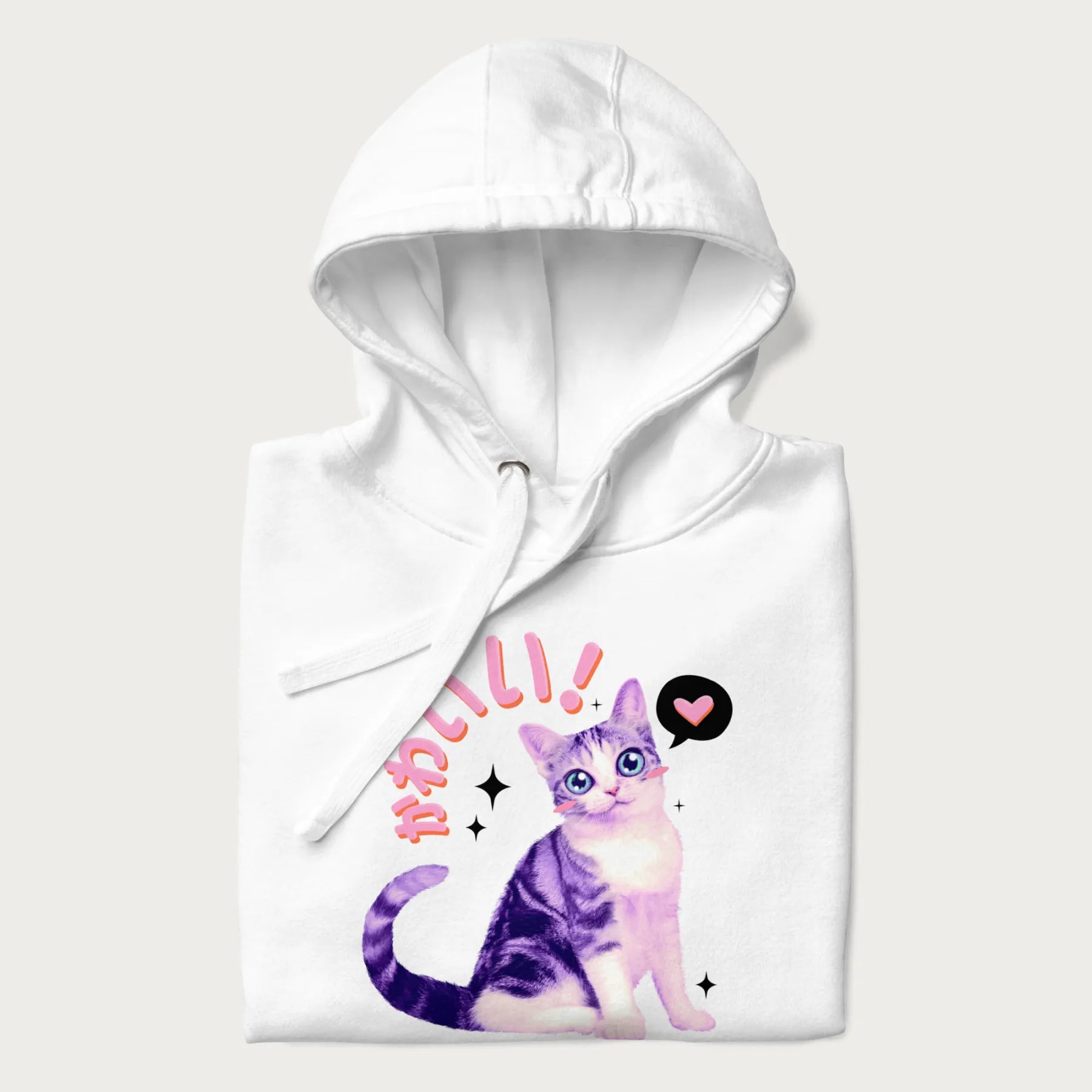 Folded white hoodie with a graphic of a blue-eyed kitten and Japanese kawaii-style lettering, stars, and a heart.