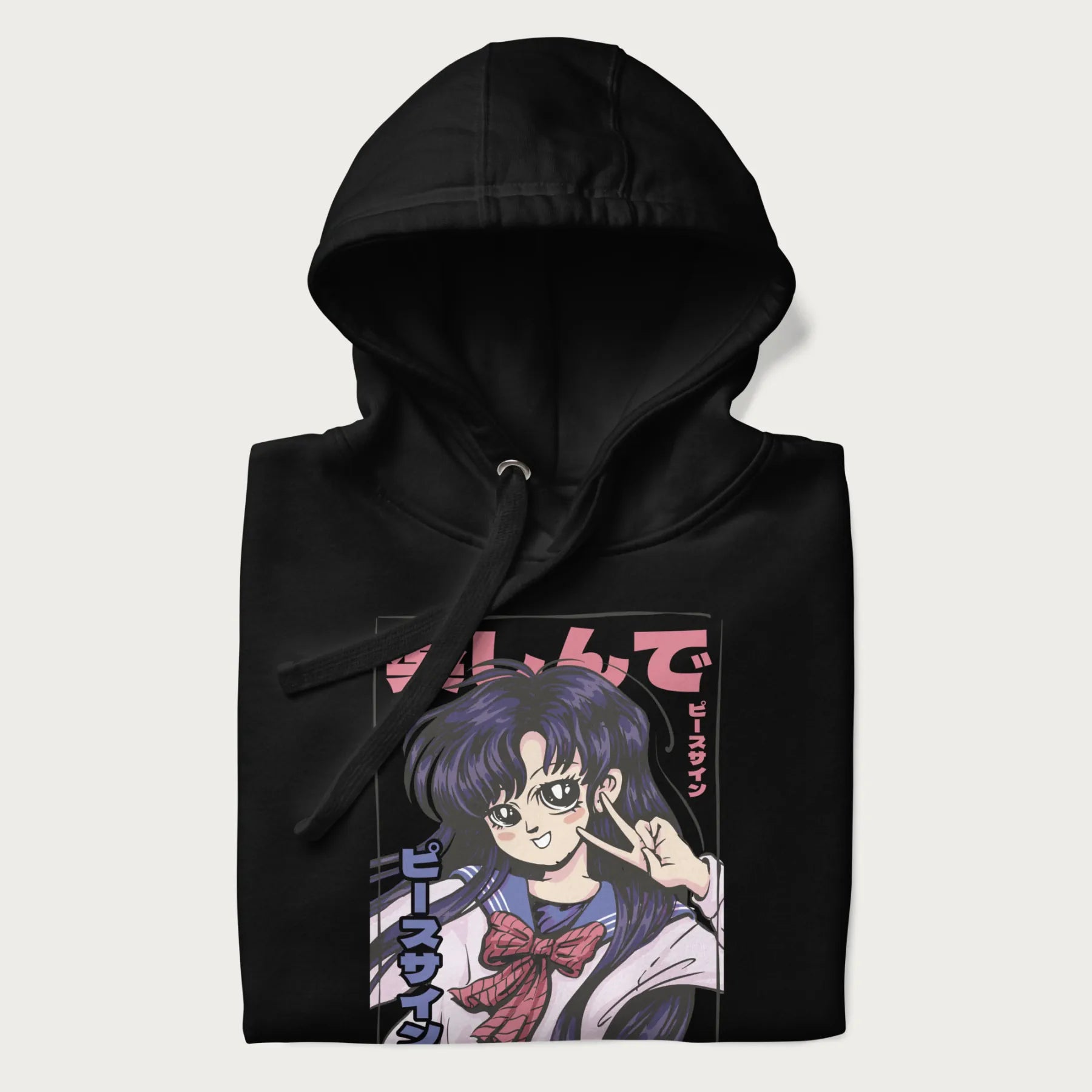 Folded black hoodie with Japanese graphic of an anime girl making a peace sign, with Japanese text '楽しんで' (Enjoy) and 'ピースサイン' (Peace Sign).