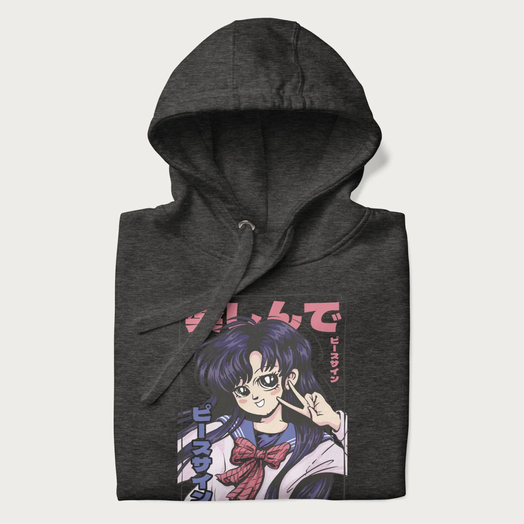 Folded dark grey hoodie with Japanese graphic of an anime girl making a peace sign, with Japanese text '楽しんで' (Enjoy) and 'ピースサイン' (Peace Sign).