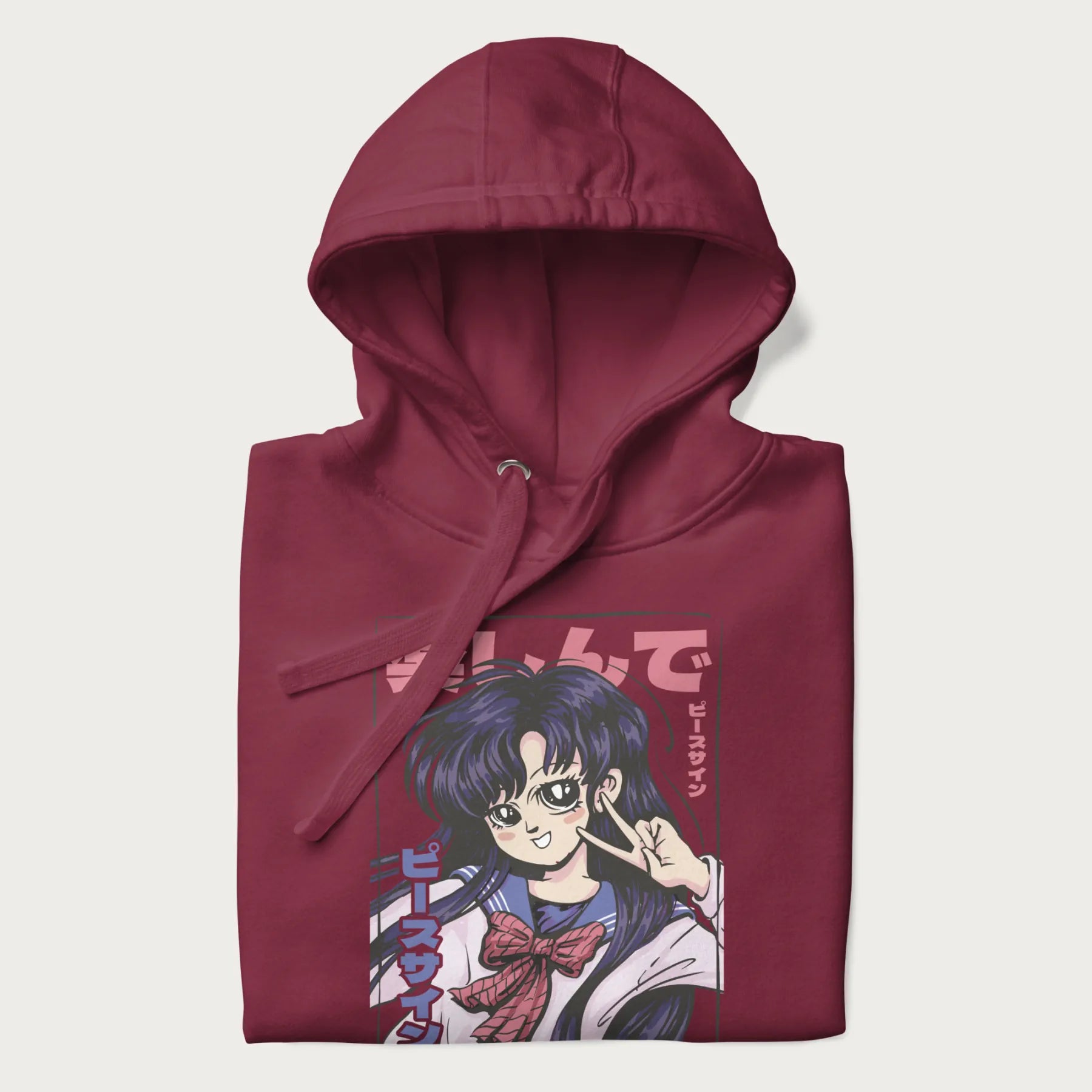 Folded maroon hoodie with Japanese graphic of an anime girl making a peace sign, with Japanese text '楽しんで' (Enjoy) and 'ピースサイン' (Peace Sign).