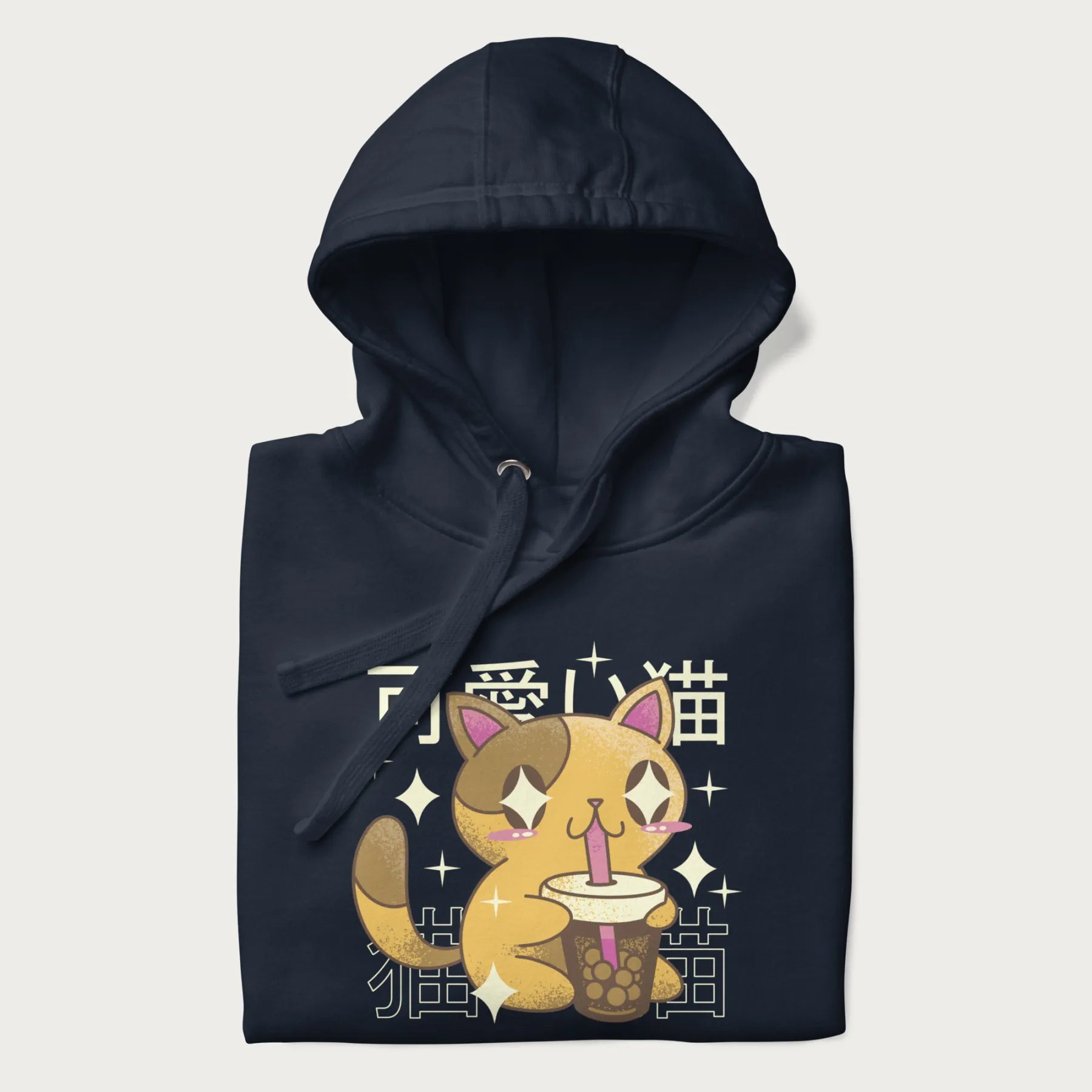 Folded navy blue hoodie with Japanese graphic of a cute yellow cat drinking bubble tea, with the Japanese text '可愛い猫' (Cute Cat) in the background.
