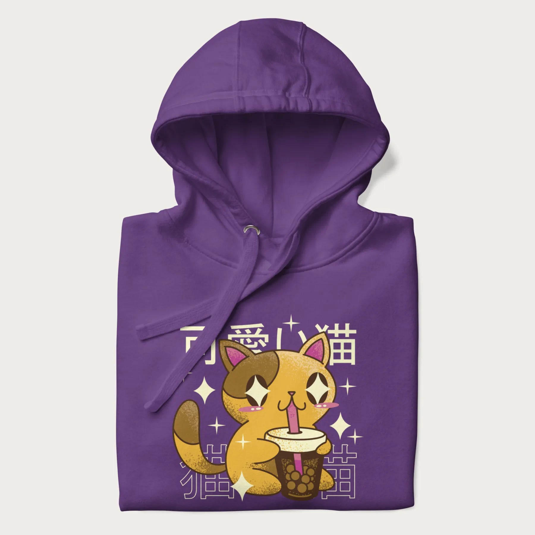Folded purple hoodie with Japanese graphic of a cute yellow cat drinking bubble tea, with the Japanese text '可愛い猫' (Cute Cat) in the background.