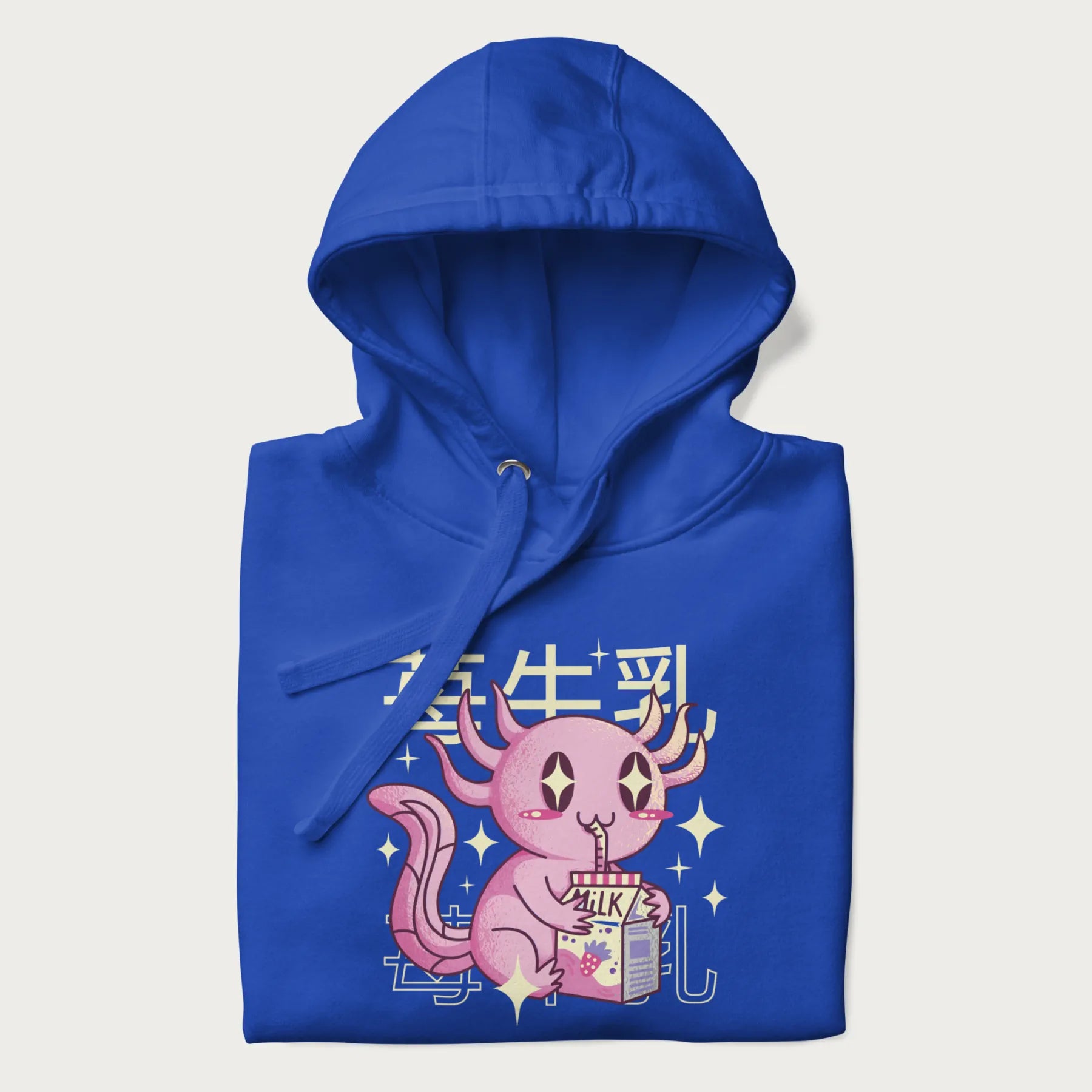 Folded royal blue hoodie with Japanese graphic of a cute pink axolotl sipping strawberry milk from a carton, with Japanese text '苺牛乳' (Strawberry Milk).