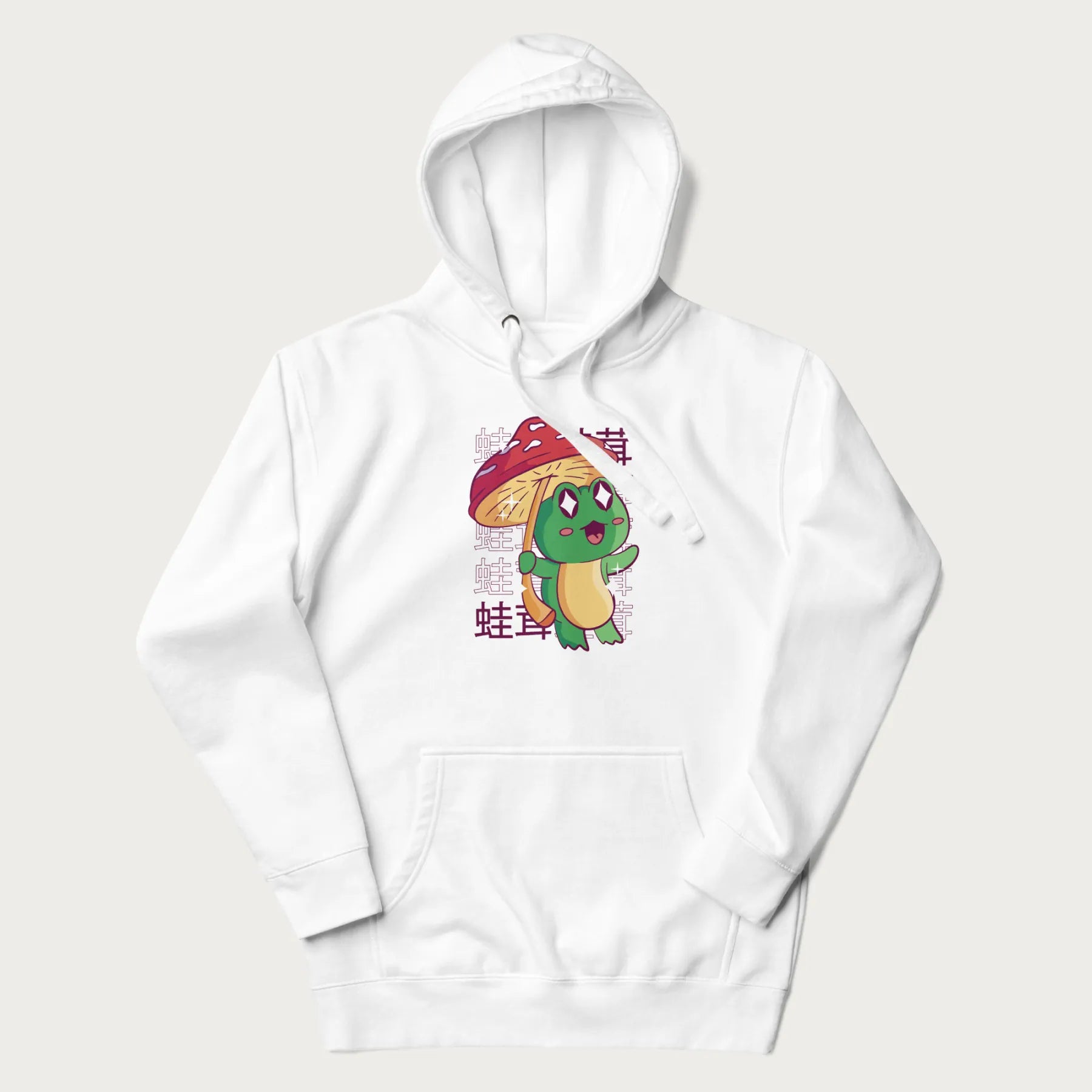 White hoodie with Japanese graphic of a cute green frog holding a red mushroom and Japanese text '蛙茸' in the background.