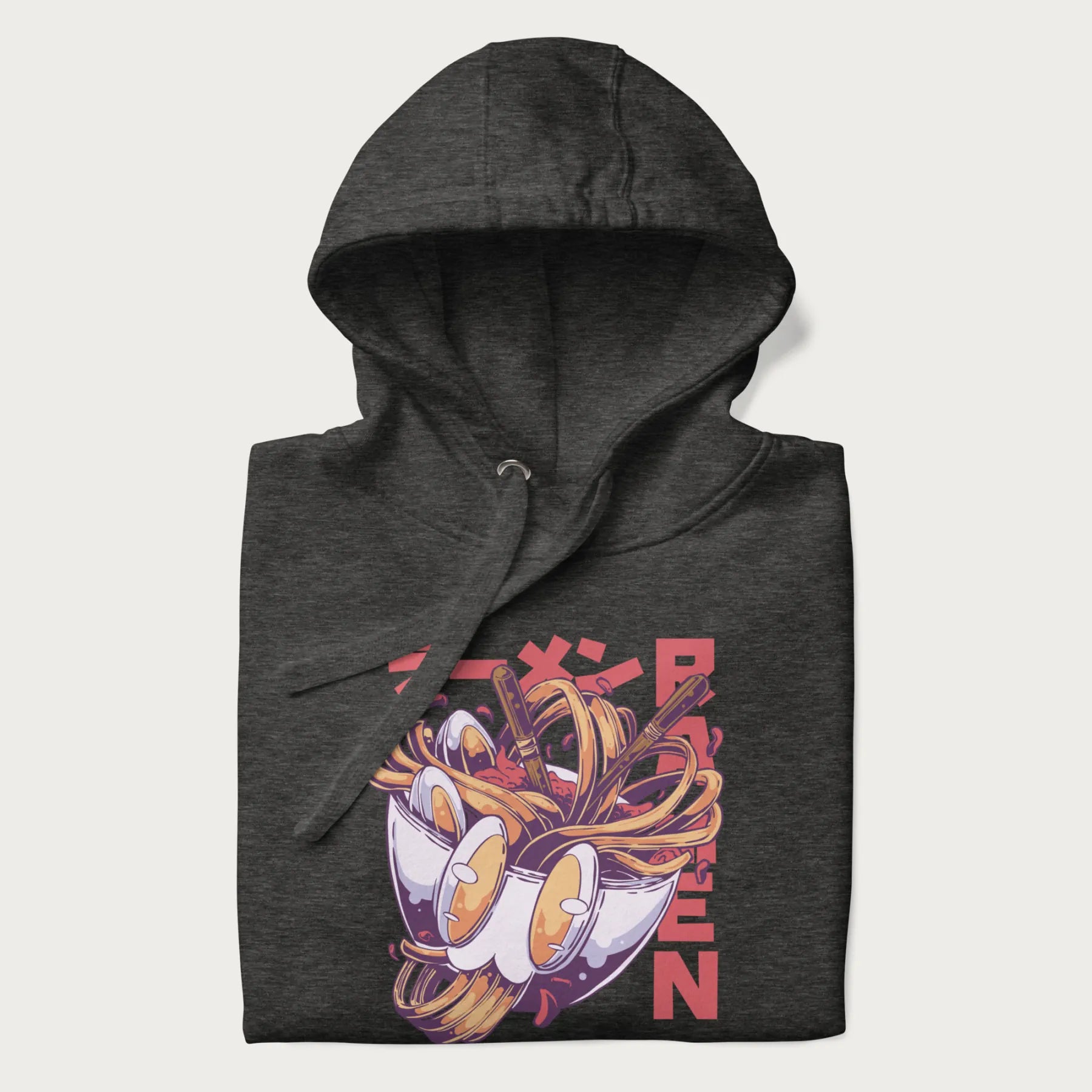Folded dark grey hoodie with Japanese graphic of a ramen bowl with noodles, eggs and Japanese text 'ラーメン' (Ramen) in bold red text.