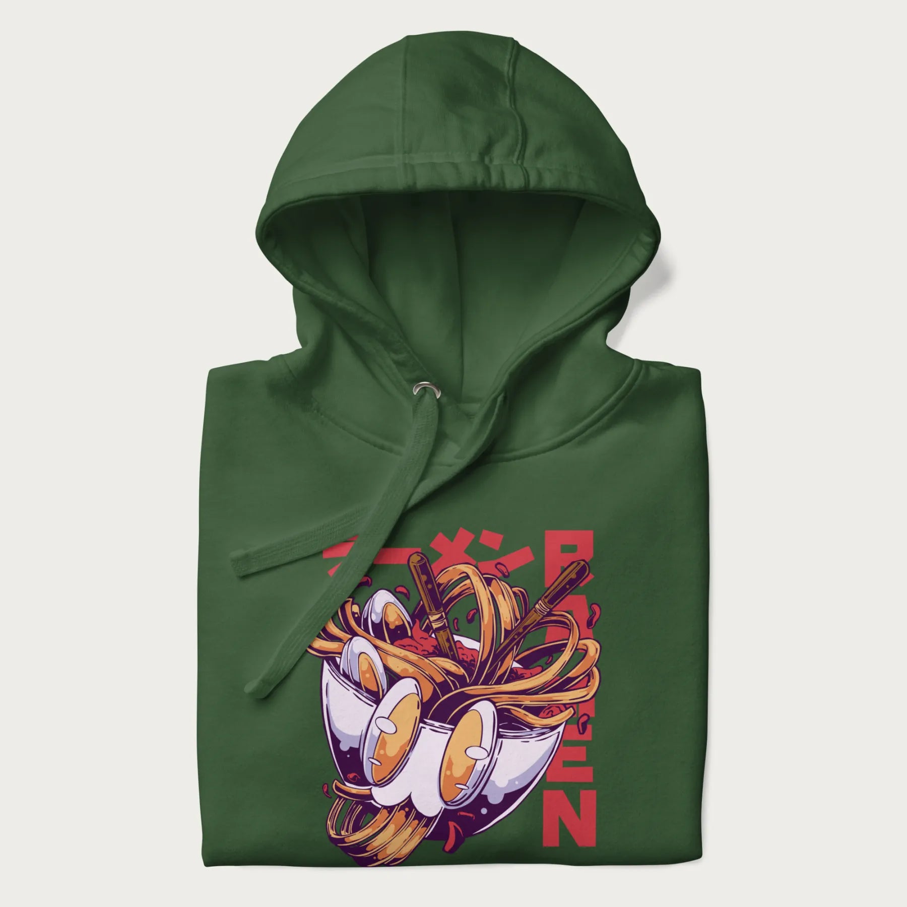 Folded forest green hoodie with Japanese graphic of a ramen bowl with noodles, eggs and Japanese text 'ラーメン' (Ramen) in bold red text.
