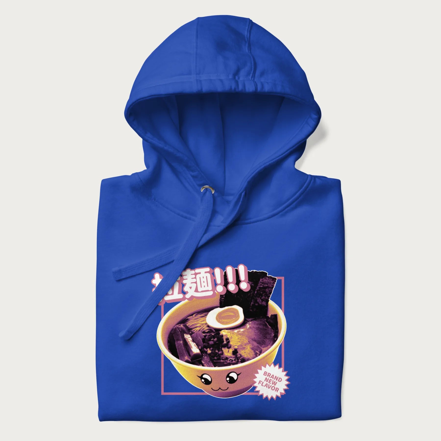 Folded royal blue hoodie with Japanese text '拉麵!!!' (Ramen!!!) in vibrant pink and realistic ramen bowl graphic.