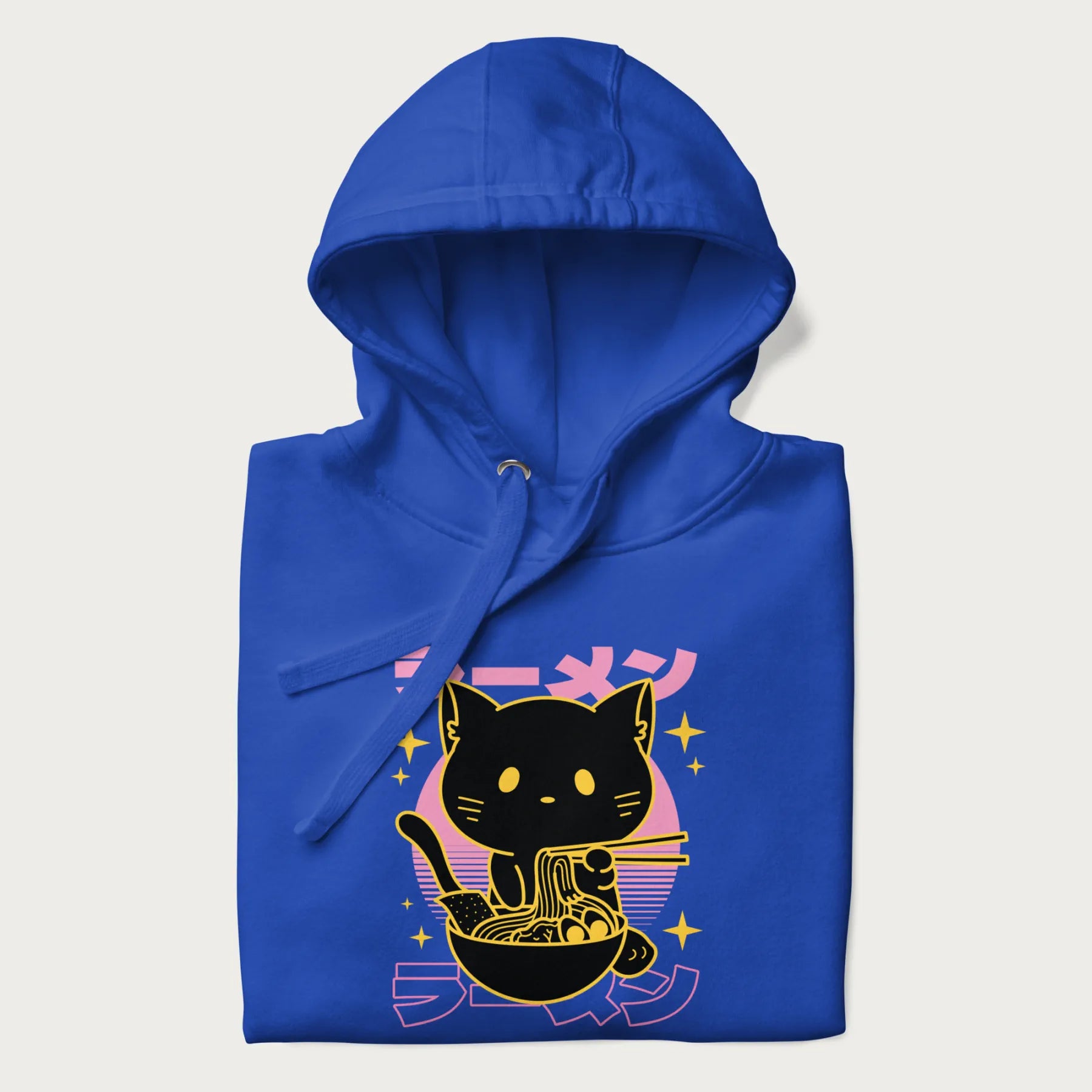 Folded royal blue hoodie with Japanese text 'ラーメン' (ramen) and a retro design of a cute black cat eating ramen.