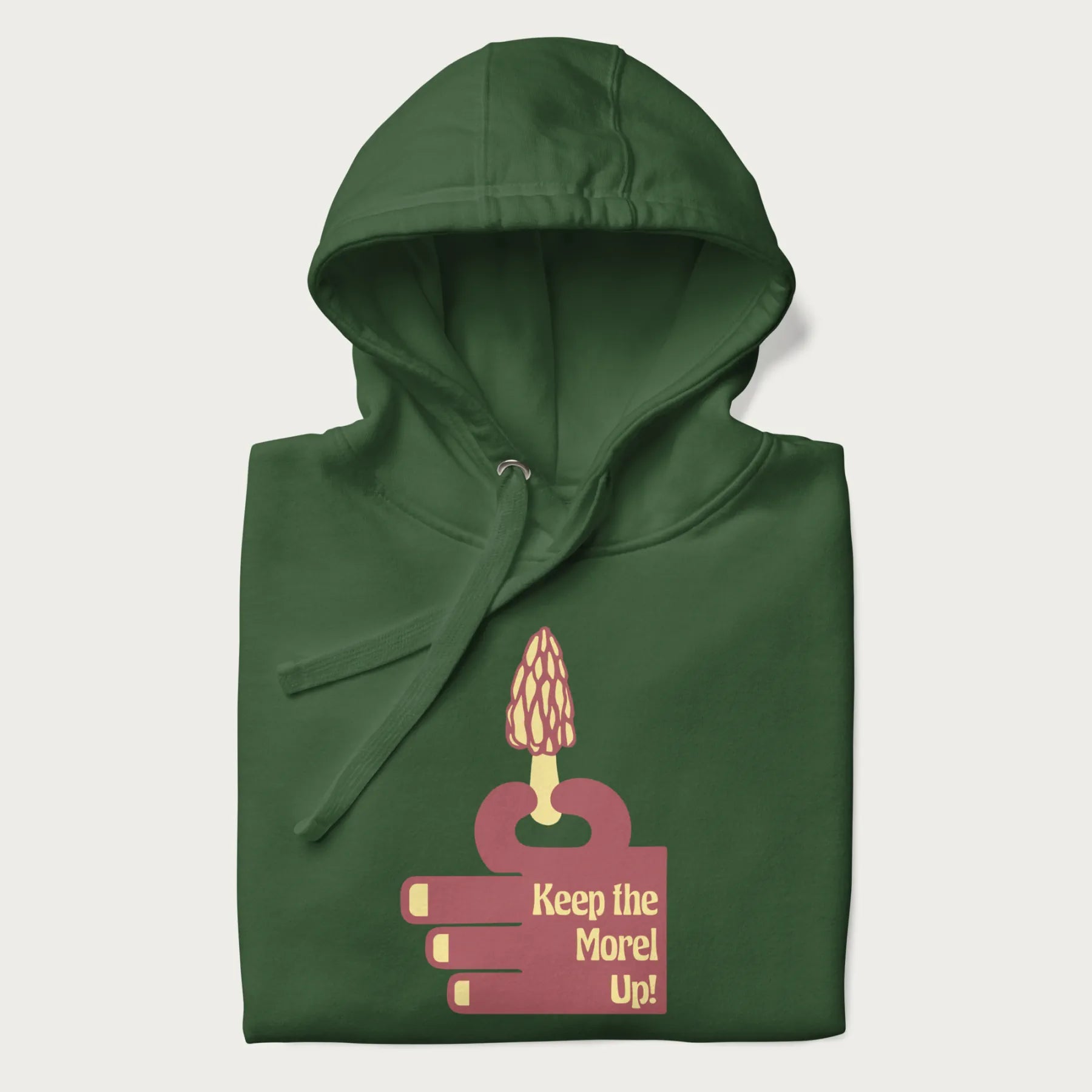 Folded forest green hoodie with a simple graphic of a hand holding a morel mushroom and the phrase 'Keep the Morel Up!'