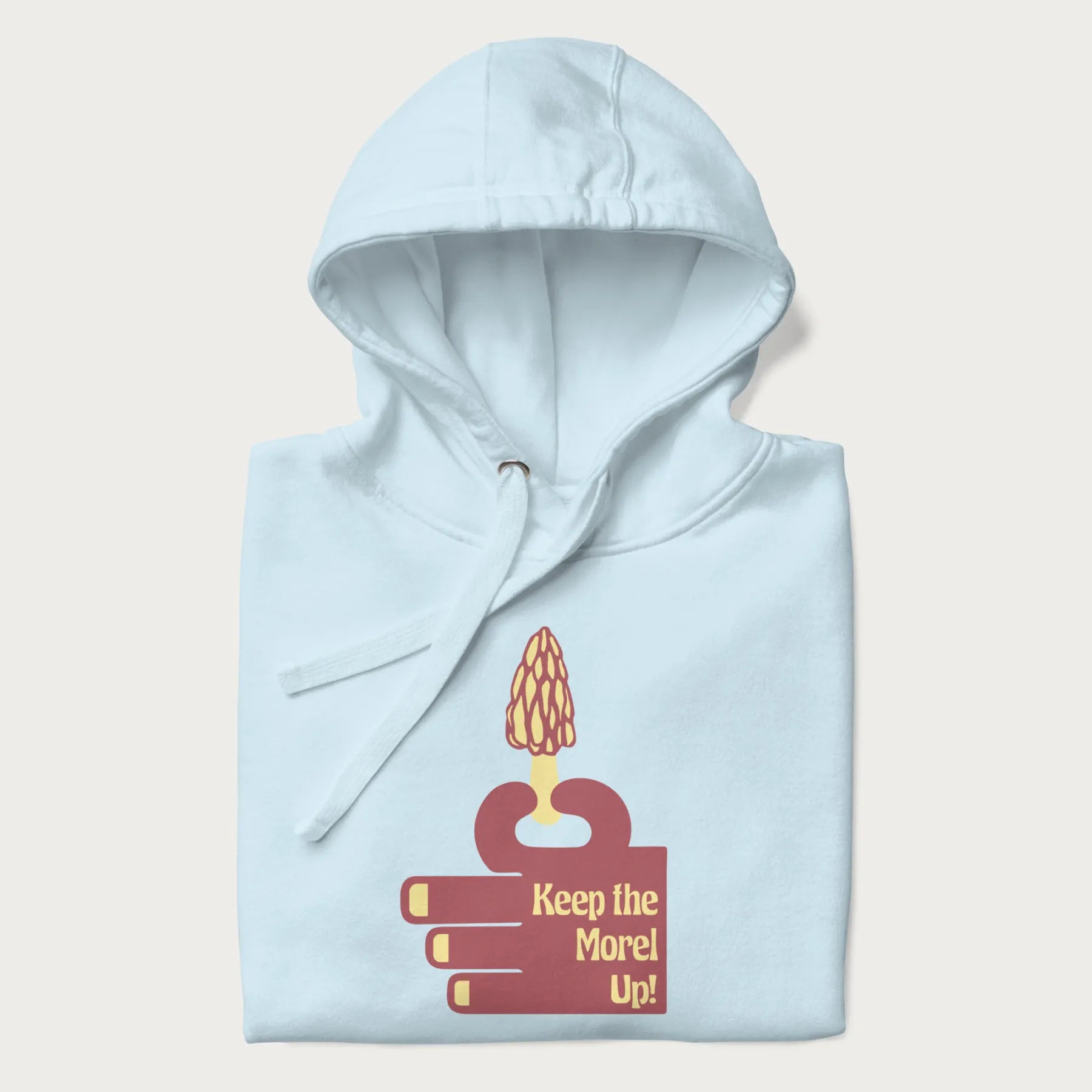 Folded light blue hoodie with a simple graphic of a hand holding a morel mushroom and the phrase 'Keep the Morel Up!'