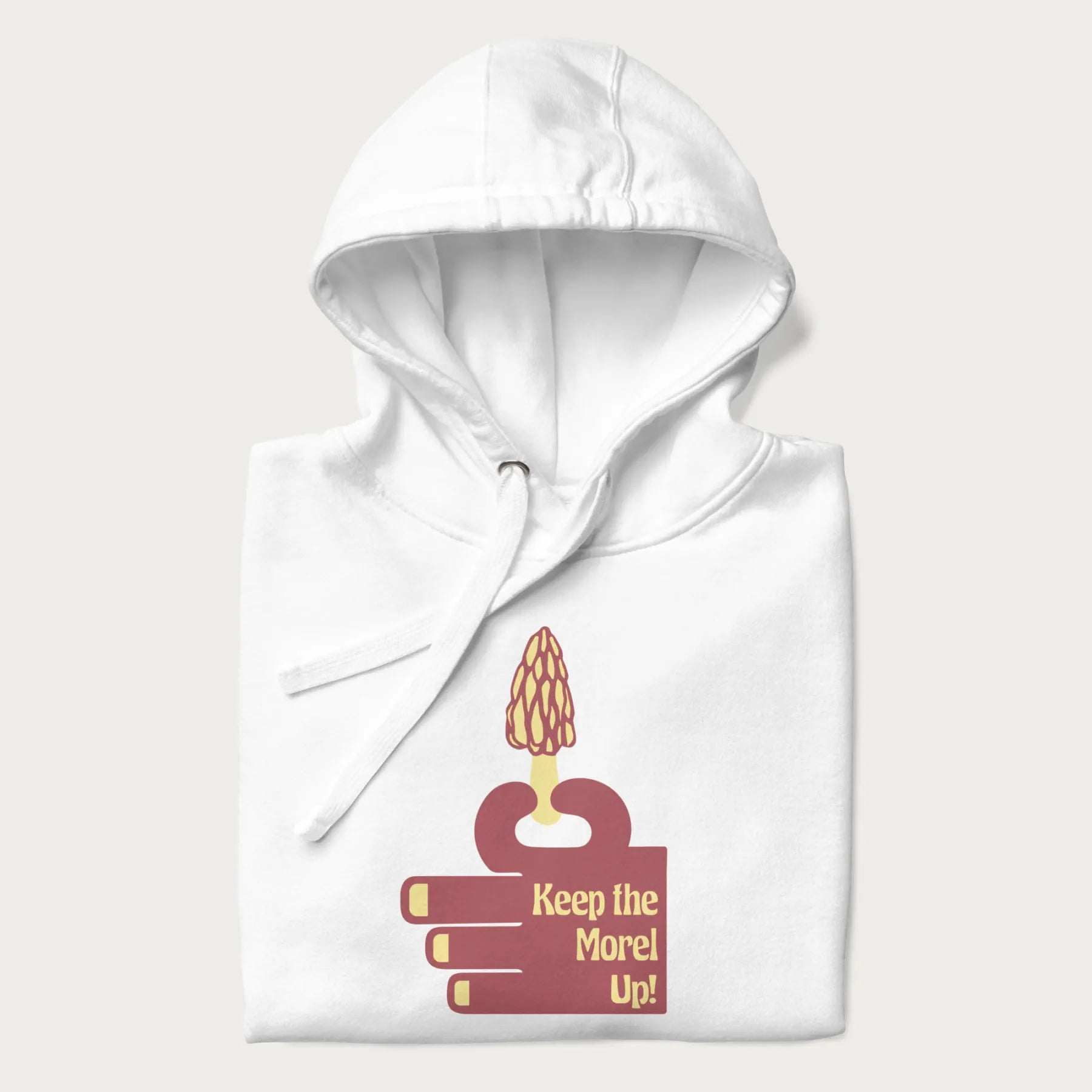 Folded white hoodie with a simple graphic of a hand holding a morel mushroom and the phrase 'Keep the Morel Up!'