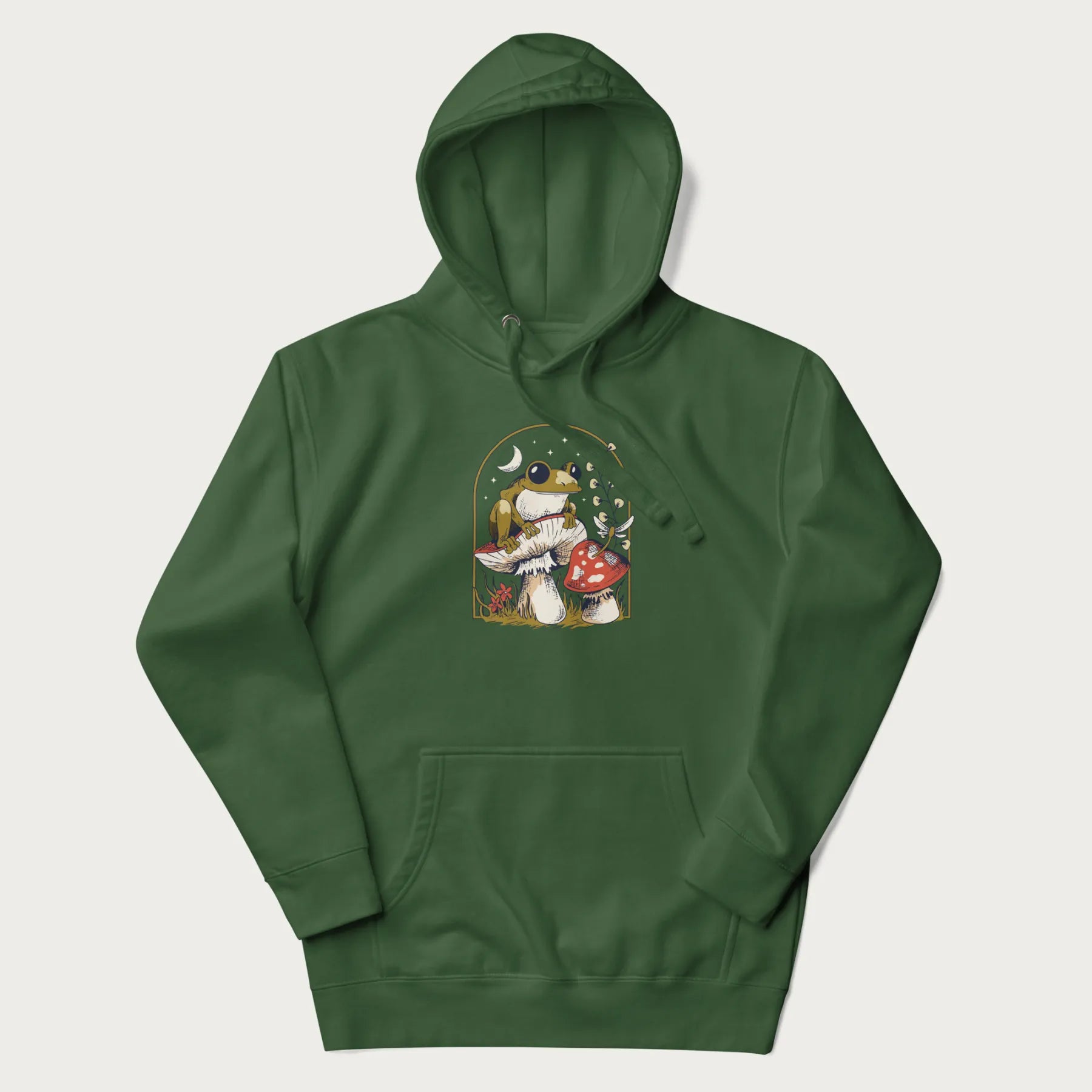 Forest green hoodie with cottagecore graphic of a frog perched on a mushroom, surrounded by additional mushrooms, flowers, and a crescent moon with stars.