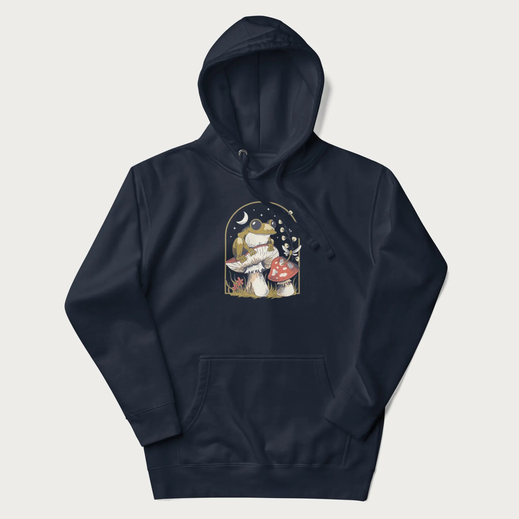 Navy blue hoodie with cottagecore graphic of a frog perched on a mushroom, surrounded by additional mushrooms, flowers, and a crescent moon with stars.