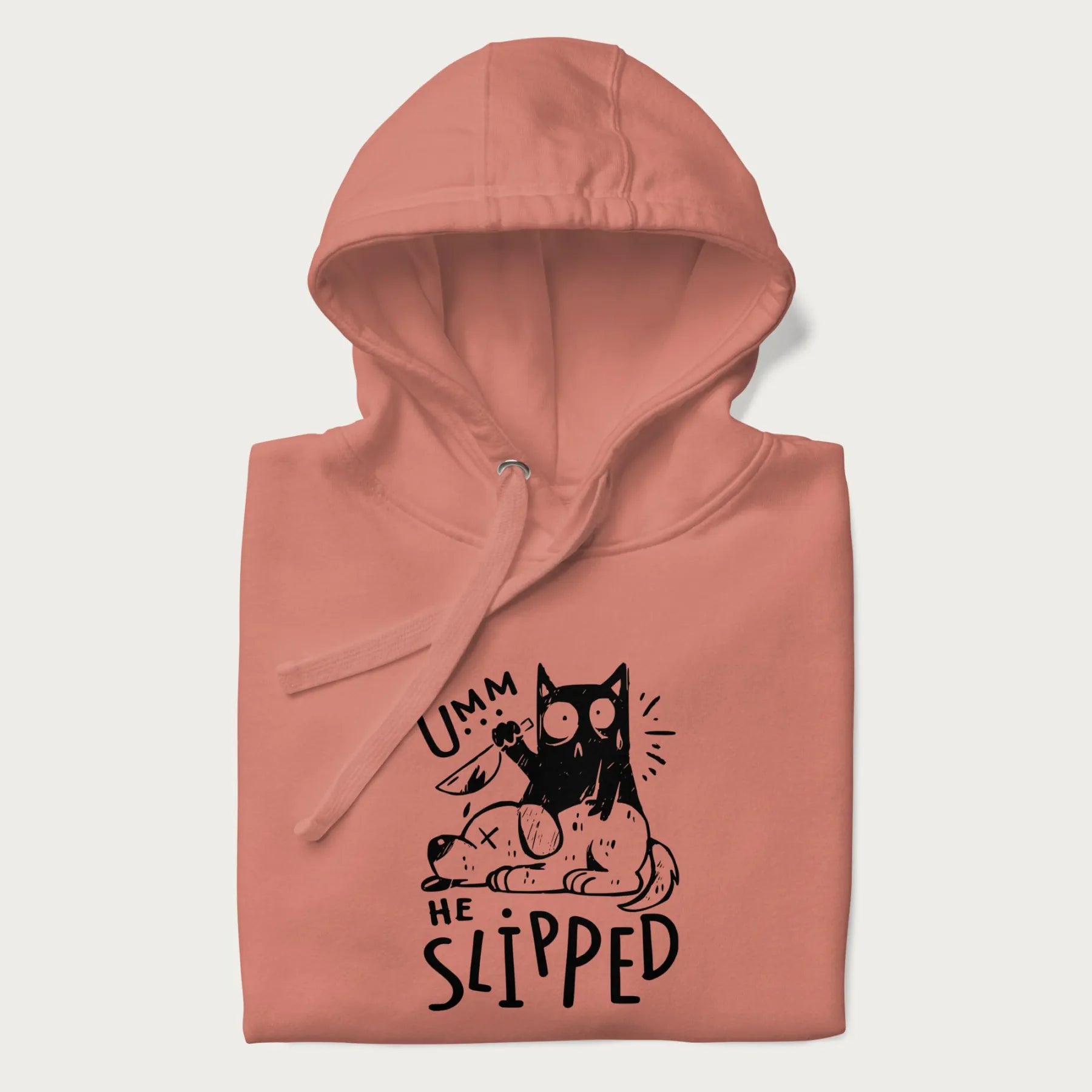 Folded light pink hoodie with a graphic of a black cat holding a knife over a dog with a funny phrase 'Umm, He Slipped'.