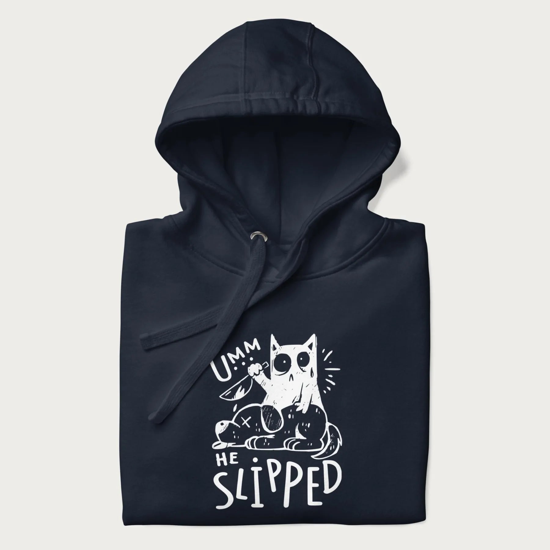 Folded navy blue hoodie with a graphic of a white cat holding a knife over a dog with a funny phrase 'Umm, He Slipped'.