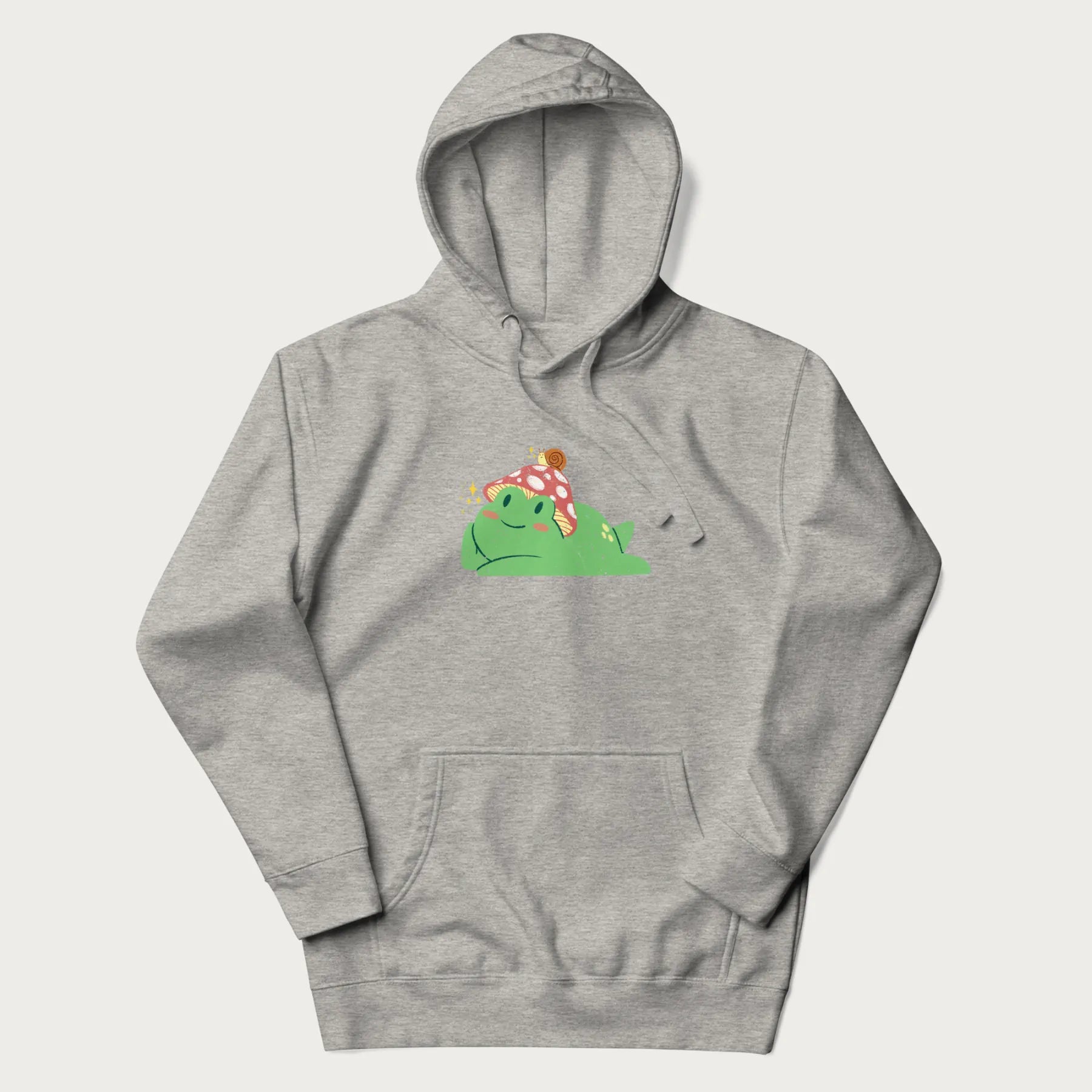 Light grey hoodie with a cottagecore design of a green frog wearing a mushroom cap and a snail on top.