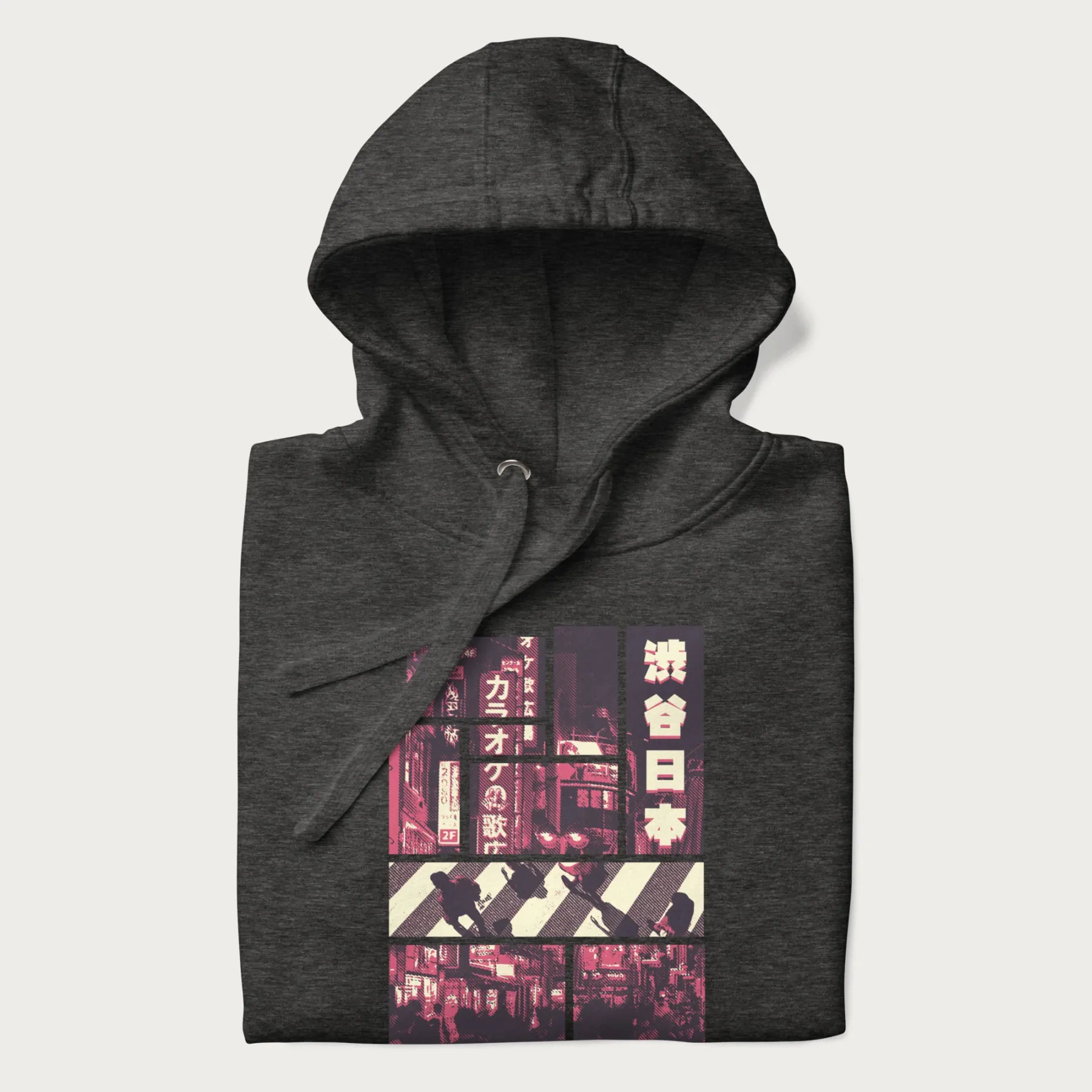 Folded dark grey hoodie with Japanese graphic panels of Shibuya Crossing, Japanese text, and neon signs.