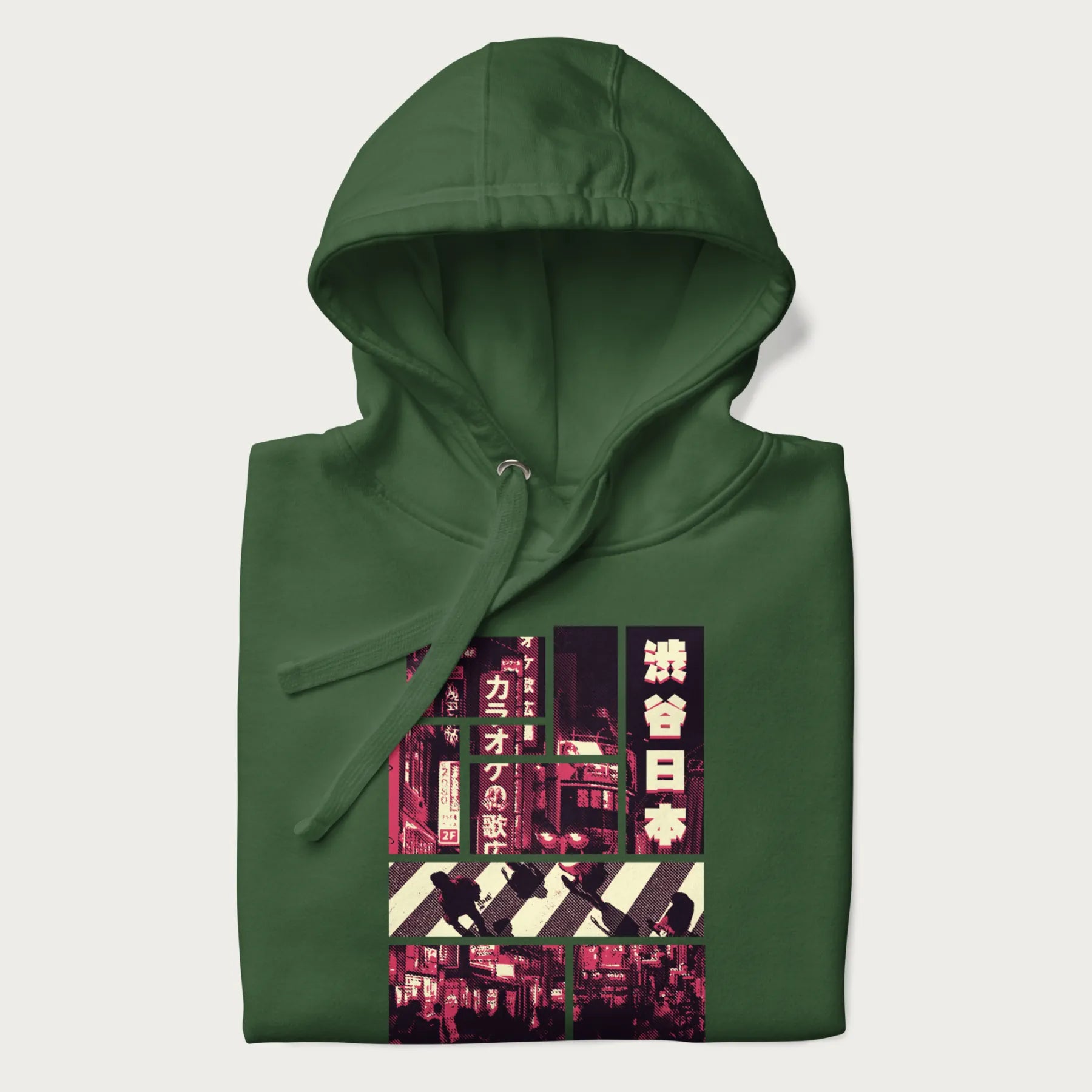 Folded forest green hoodie with Japanese graphic panels of Shibuya Crossing, Japanese text, and neon signs.