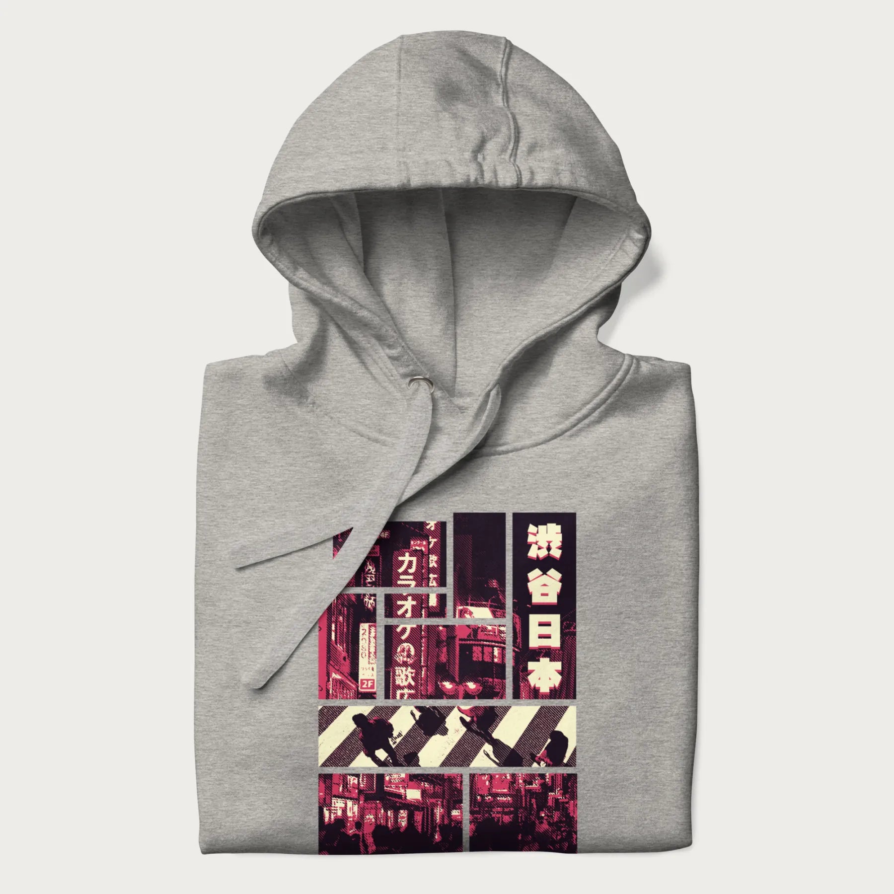 Folded light grey hoodie with Japanese graphic panels of Shibuya Crossing, Japanese text, and neon signs.