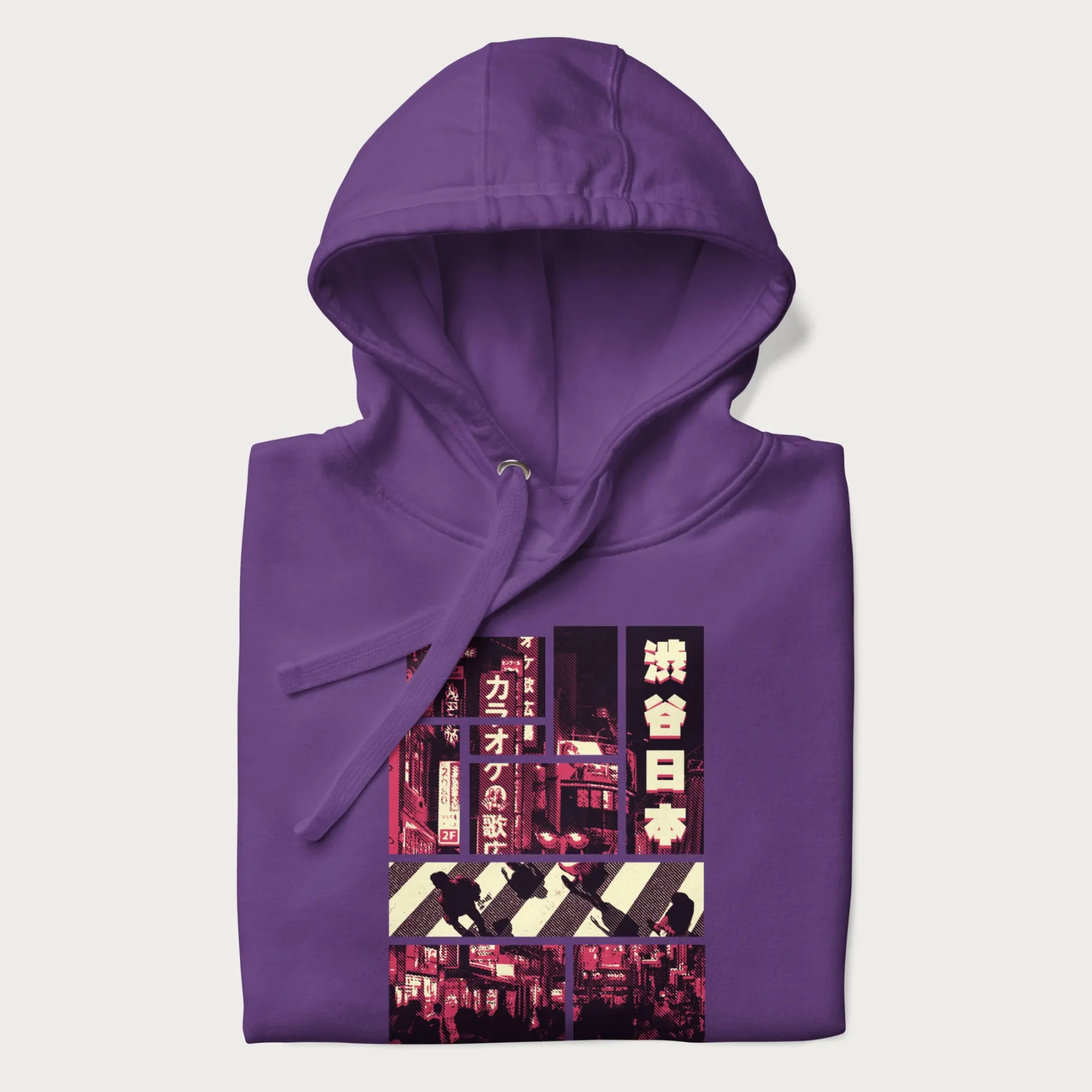 Folded purple hoodie with Japanese graphic panels of Shibuya Crossing, Japanese text, and neon signs.