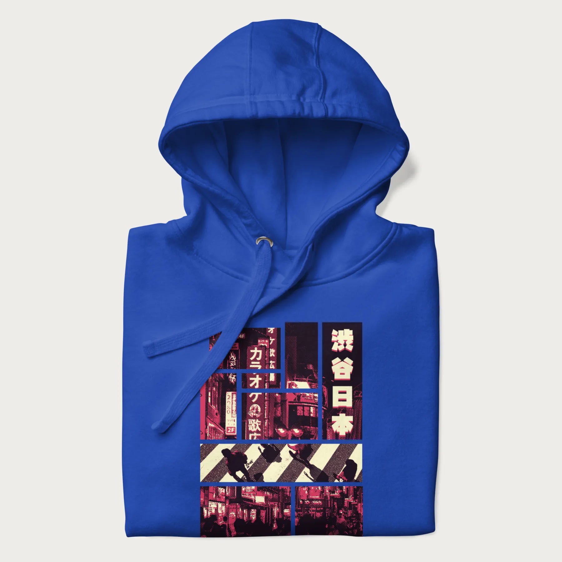 Folded royal blue hoodie with Japanese graphic panels of Shibuya Crossing, Japanese text, and neon signs.