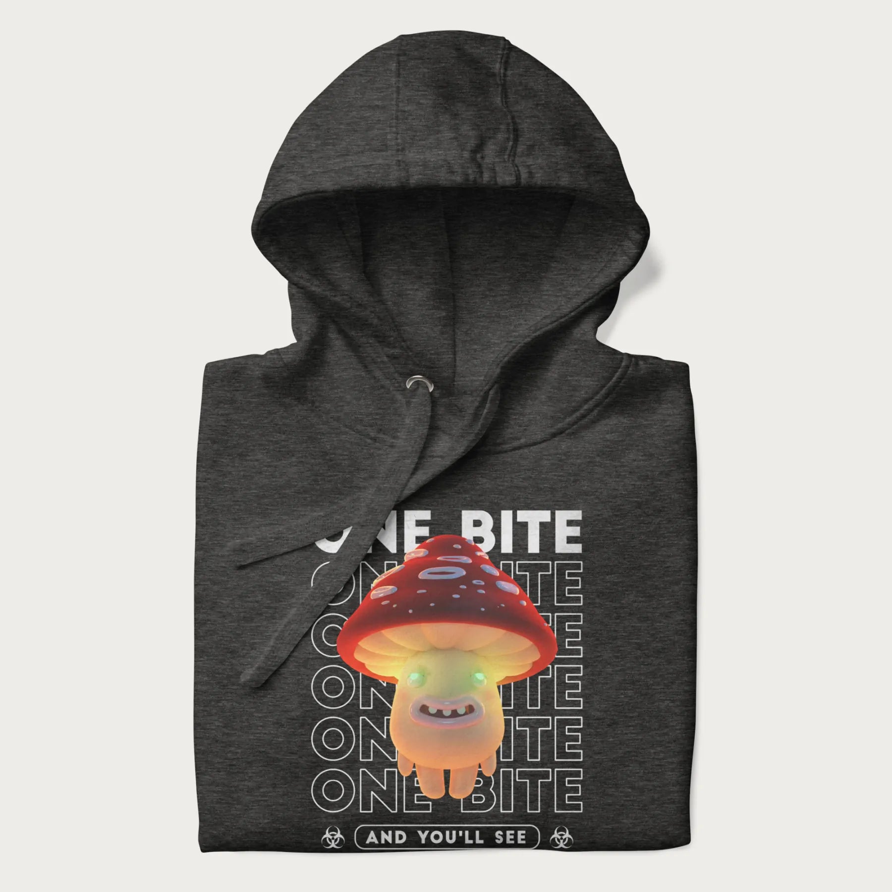 Folded dark grey hoodie with a graphic of a glowing, cartoon realistic mushroom character and the text 'One Bite And You'll See'.