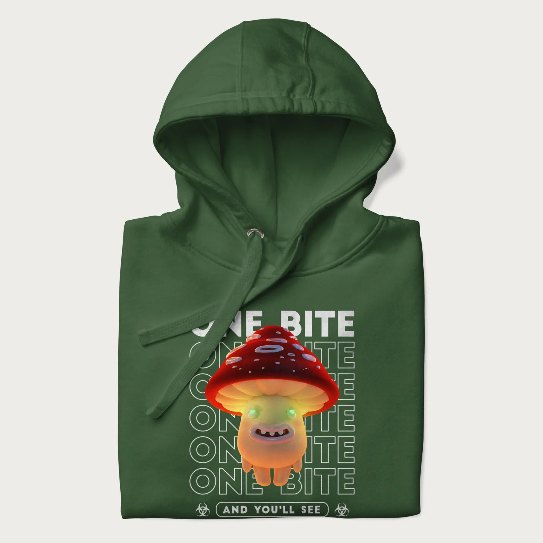 Folded forest green hoodie with a graphic of a glowing, cartoon realistic mushroom character and the text 'One Bite And You'll See'.
