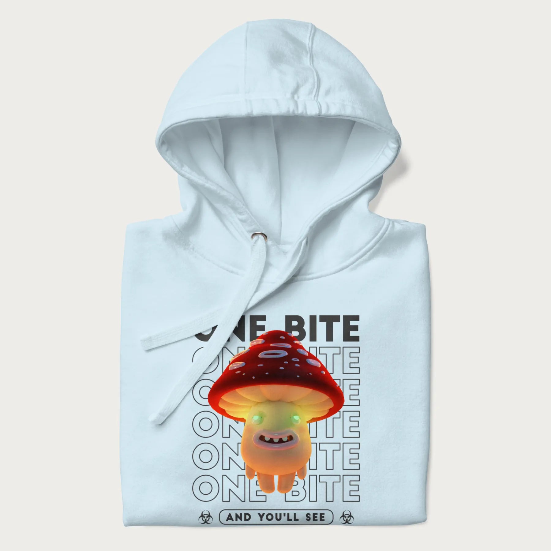 Folded light blue hoodie with a graphic of a glowing, cartoon realistic mushroom character and the text 'One Bite And You'll See'.