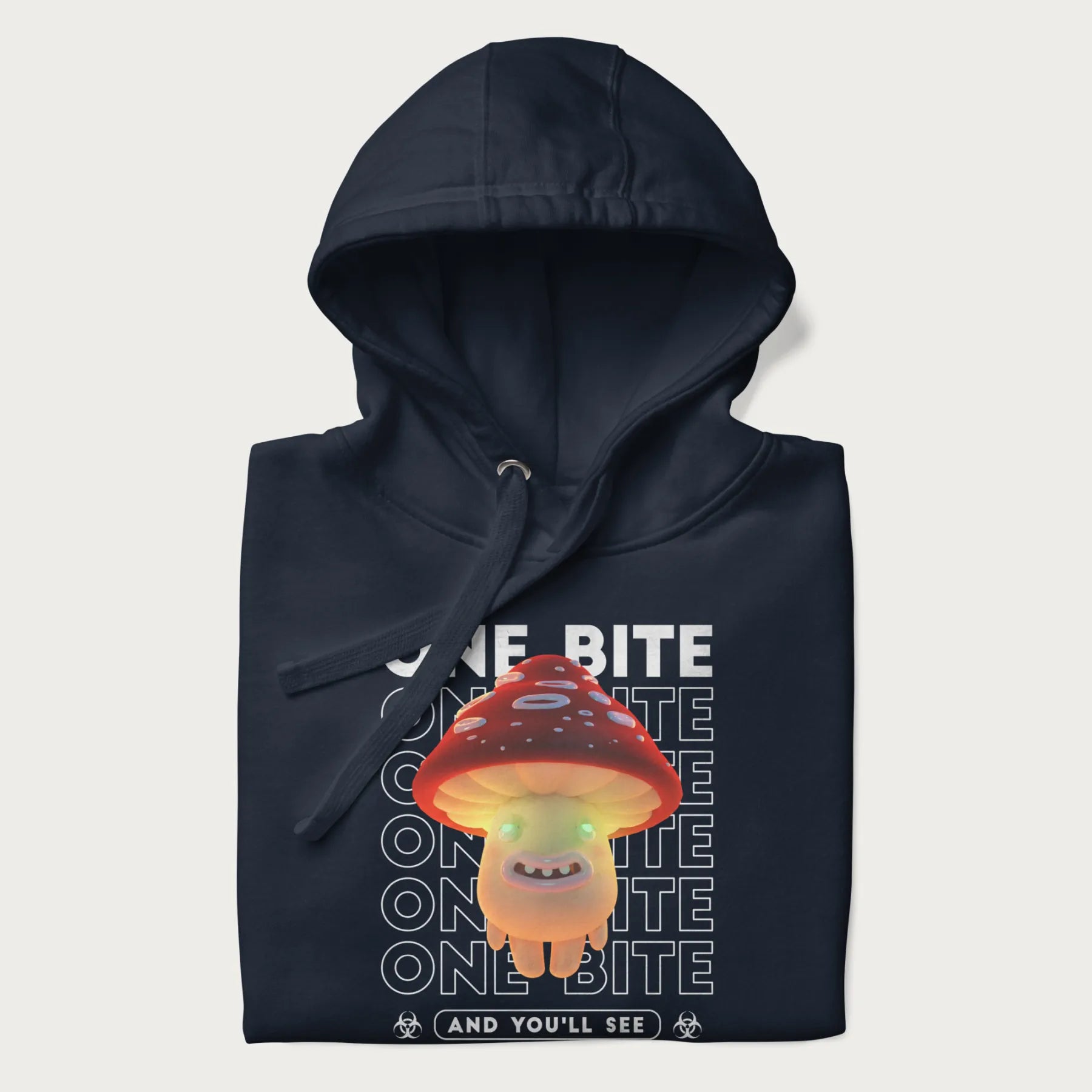 Folded navy blue hoodie with a graphic of a glowing, cartoon realistic mushroom character and the text 'One Bite And You'll See'.
