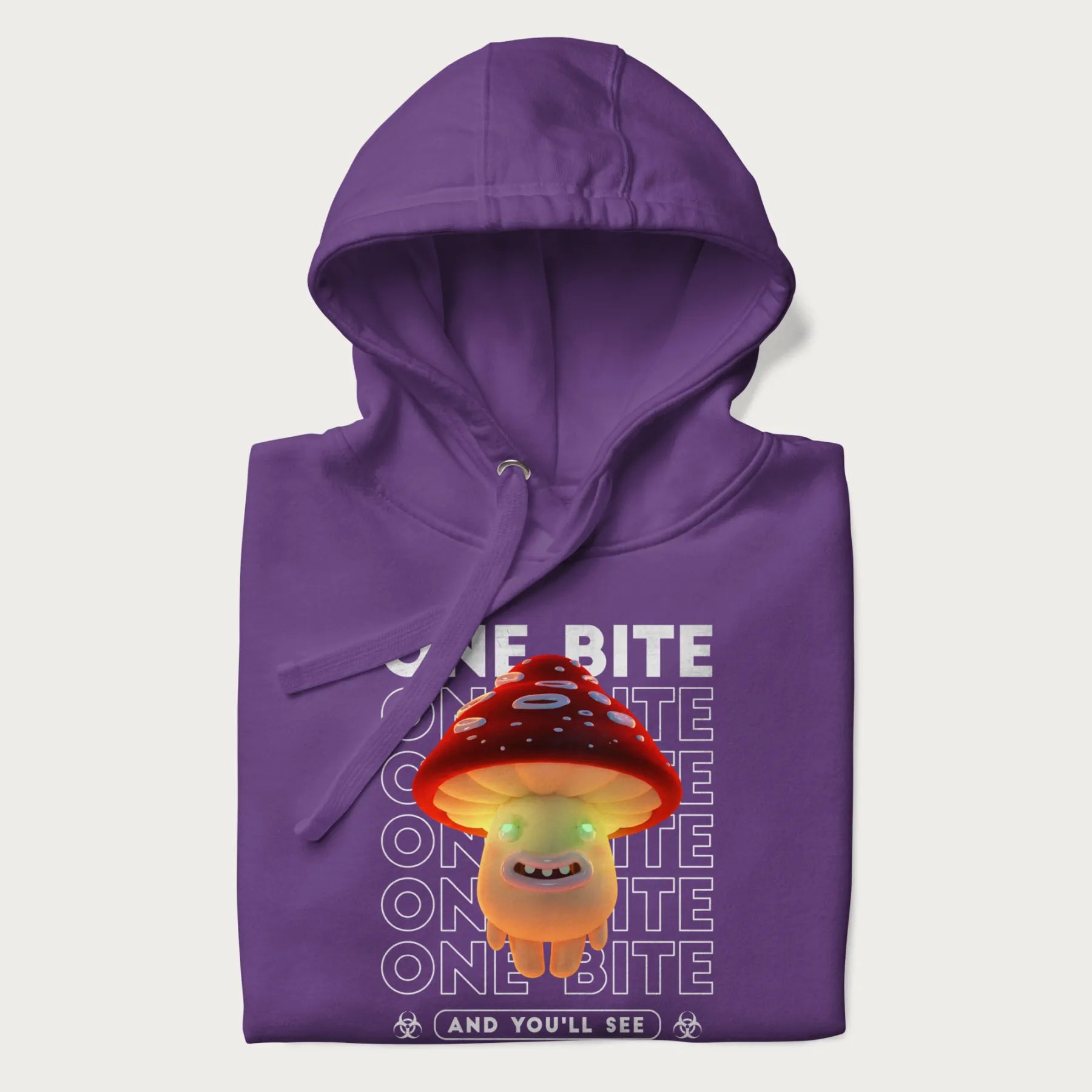 Folded purple hoodie with a graphic of a glowing, cartoon realistic mushroom character and the text 'One Bite And You'll See'.